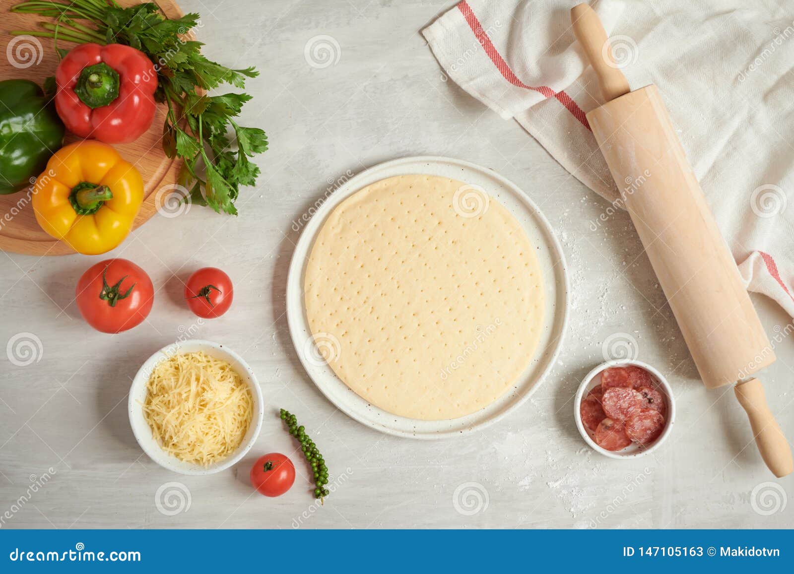 Fresh Dough Pizza Base and Ingredients on a White Table. Top View Stock