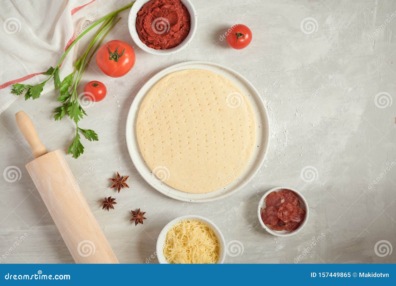 Fresh Dough Pizza Base and Ingredients on a White Table. Top View Stock