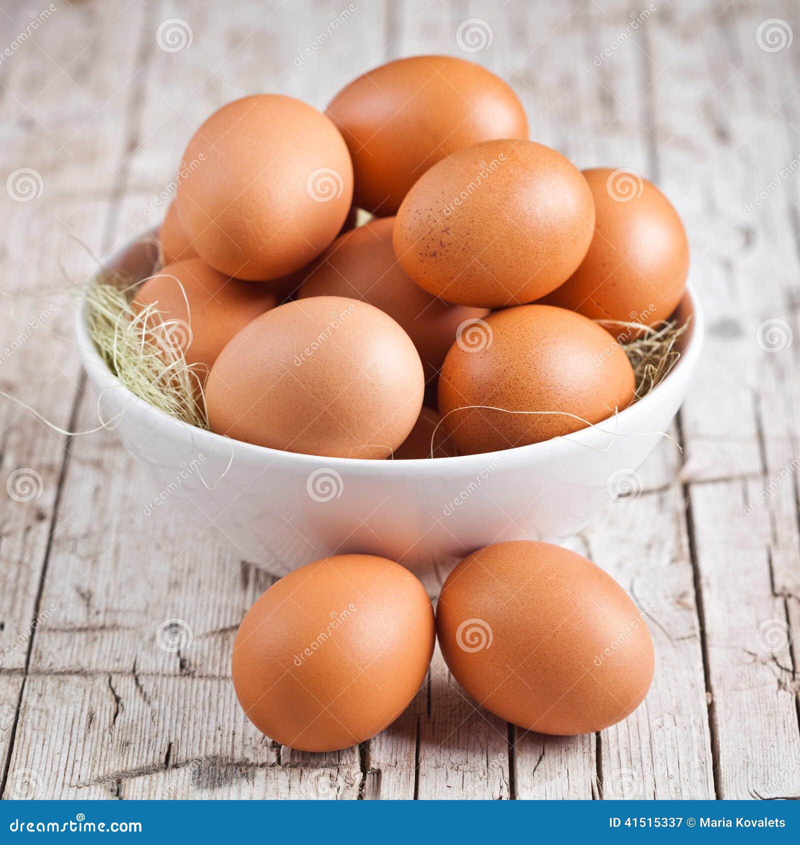 Fresh eggs in a bowl on rustic wooden background