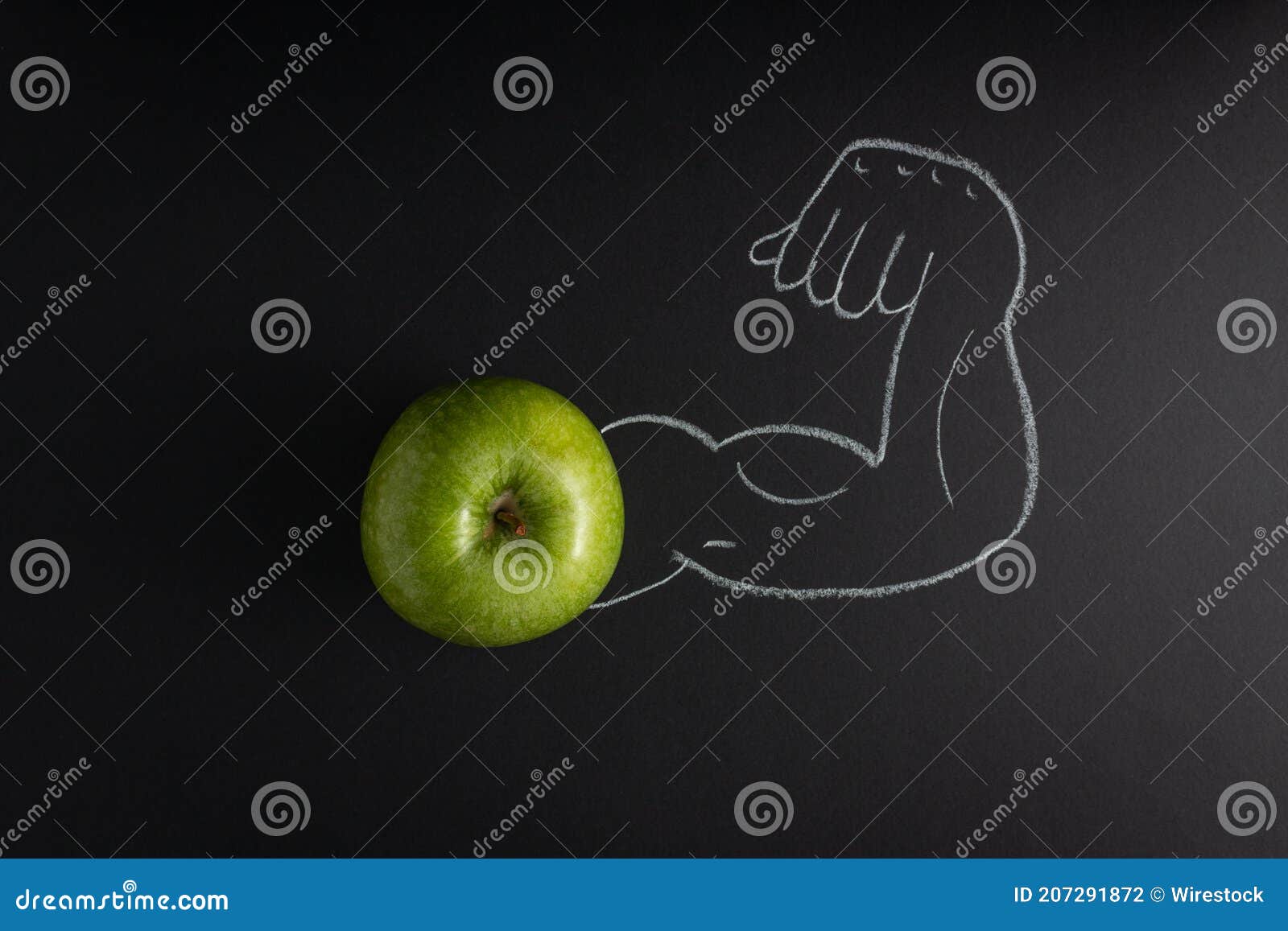 fresh green apple and a strong arm showing its biceps muscle drawn in the black background