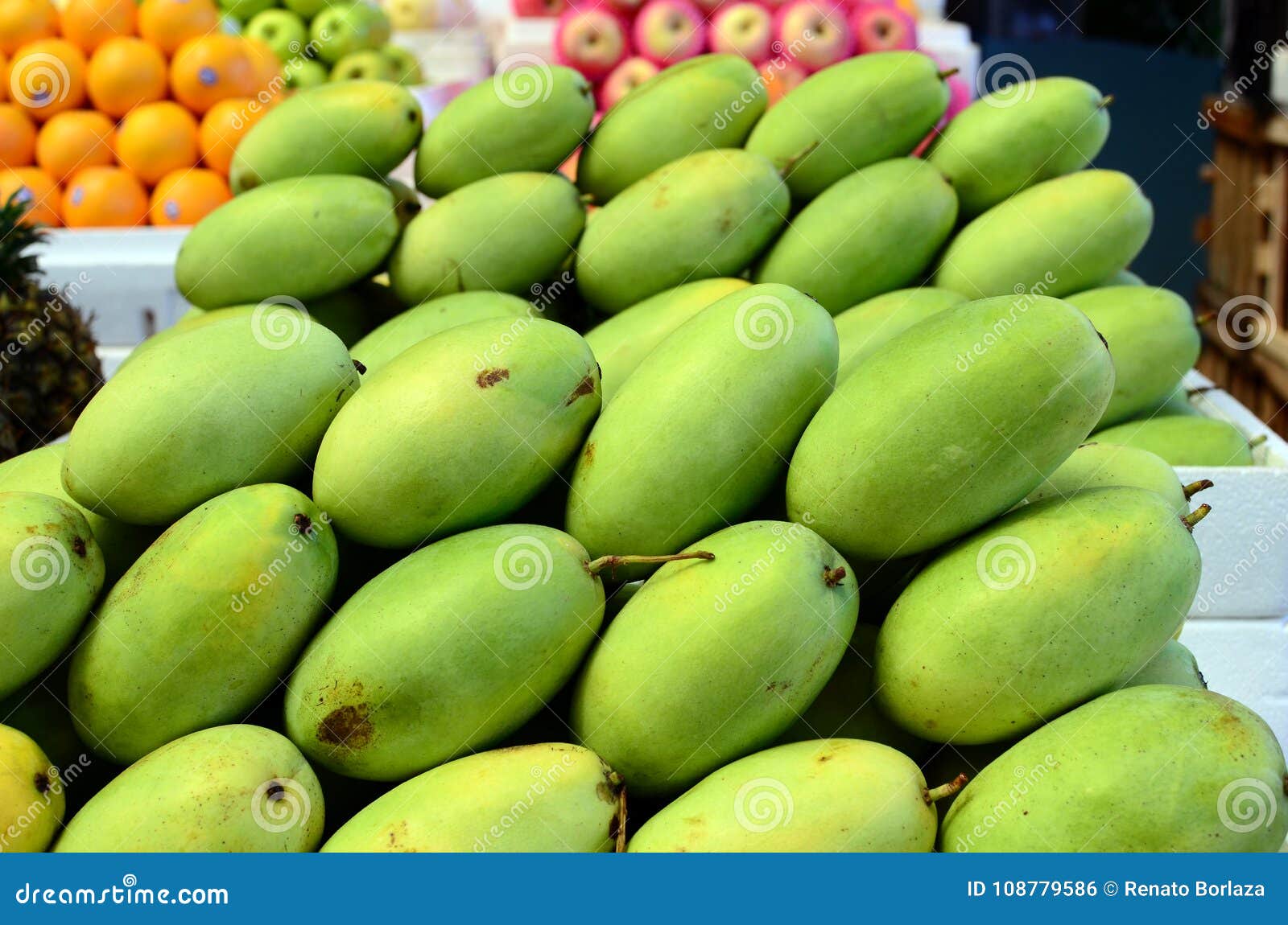 fresh green unripe mango fruits symmetrically to attract buyers at market stall