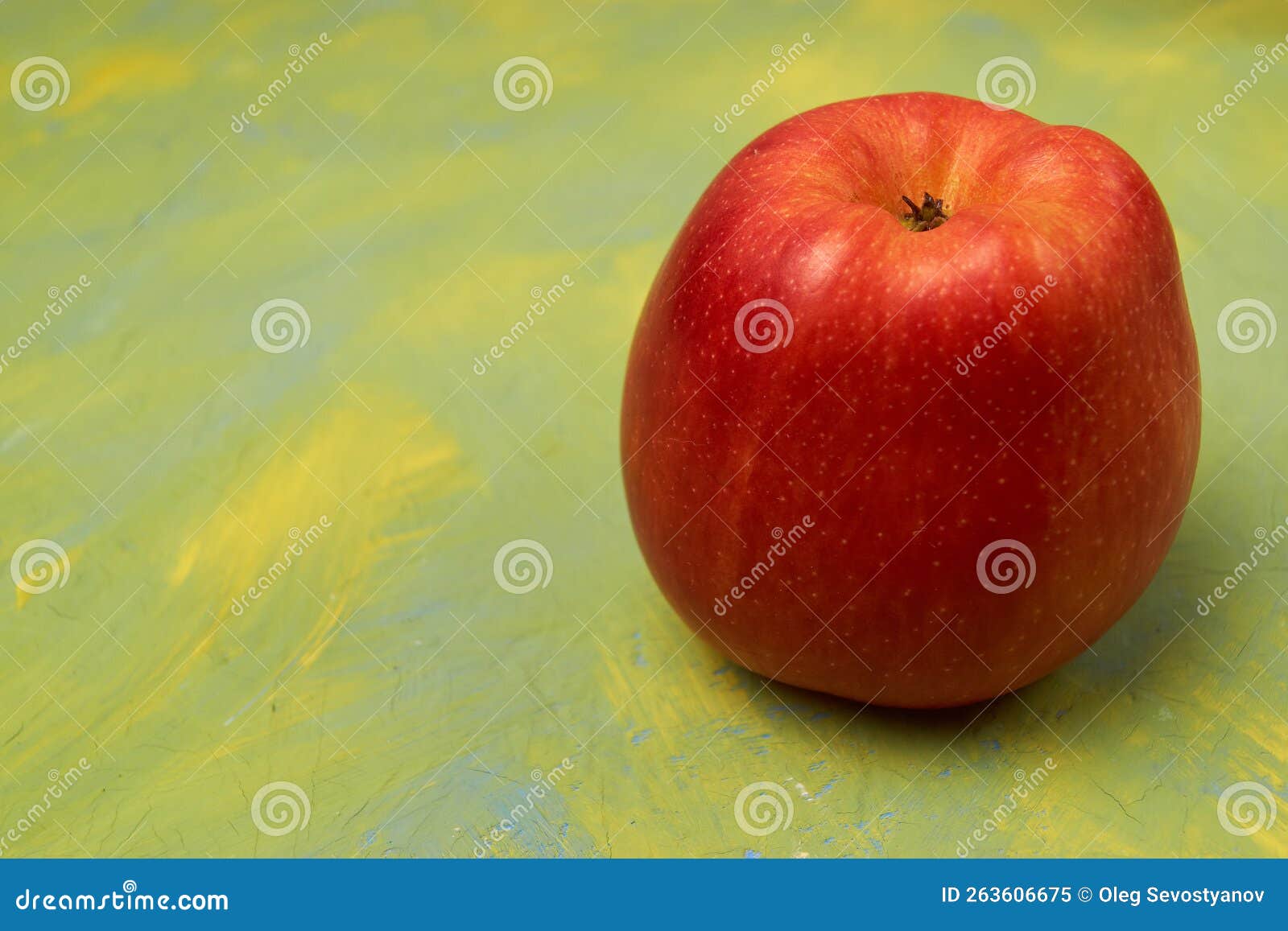Fresh Isolated Red Apple on a Yellow Green Background. Empty Space for