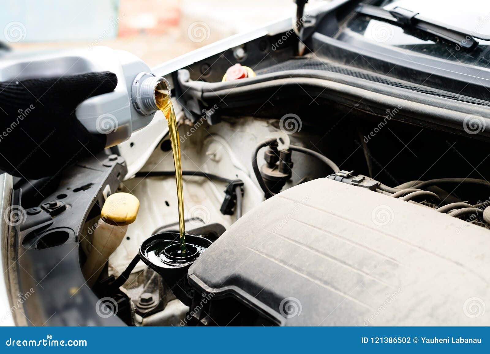 fresh oil being poured during an oil change to car engine, close