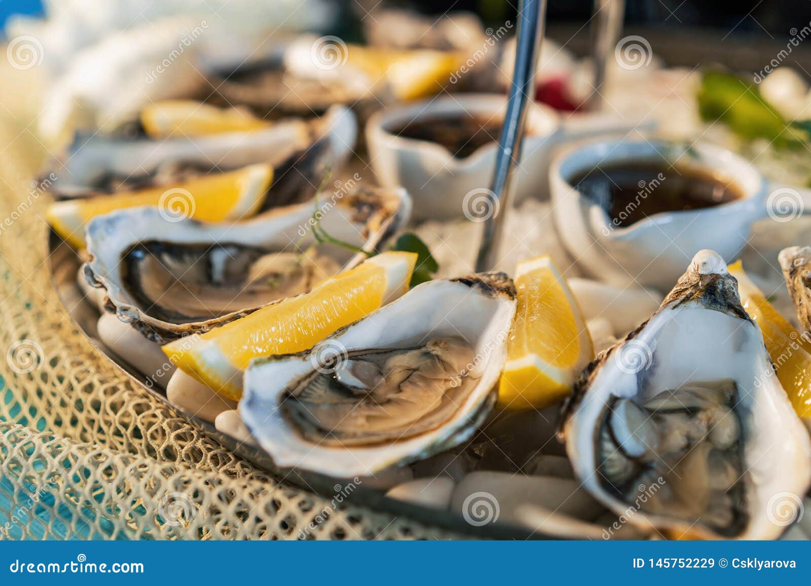 Fresh Oysters with Lemon on White Plate in Restaurant Stock Image