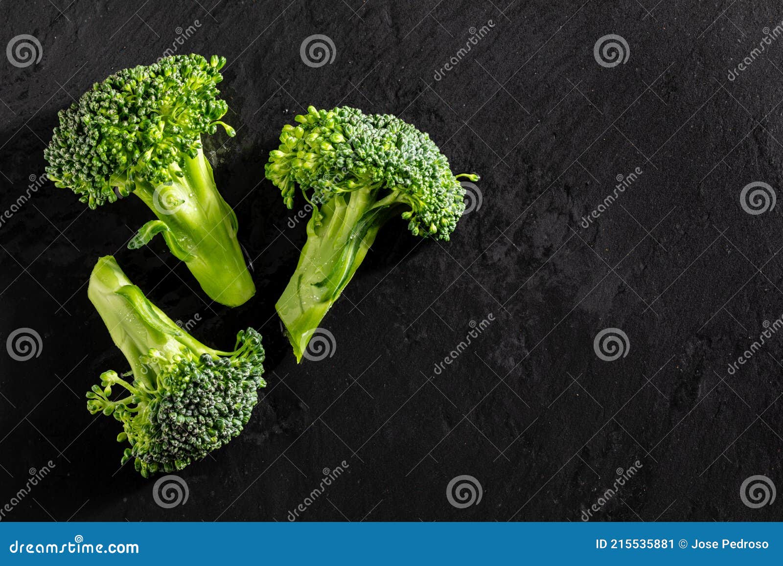 fresh raw broccoli brÃÂ©col, brÃÂ³colli, brÃÂ³qui, broccoli brote, brassica oleracea stalks with water drops on textured slate
