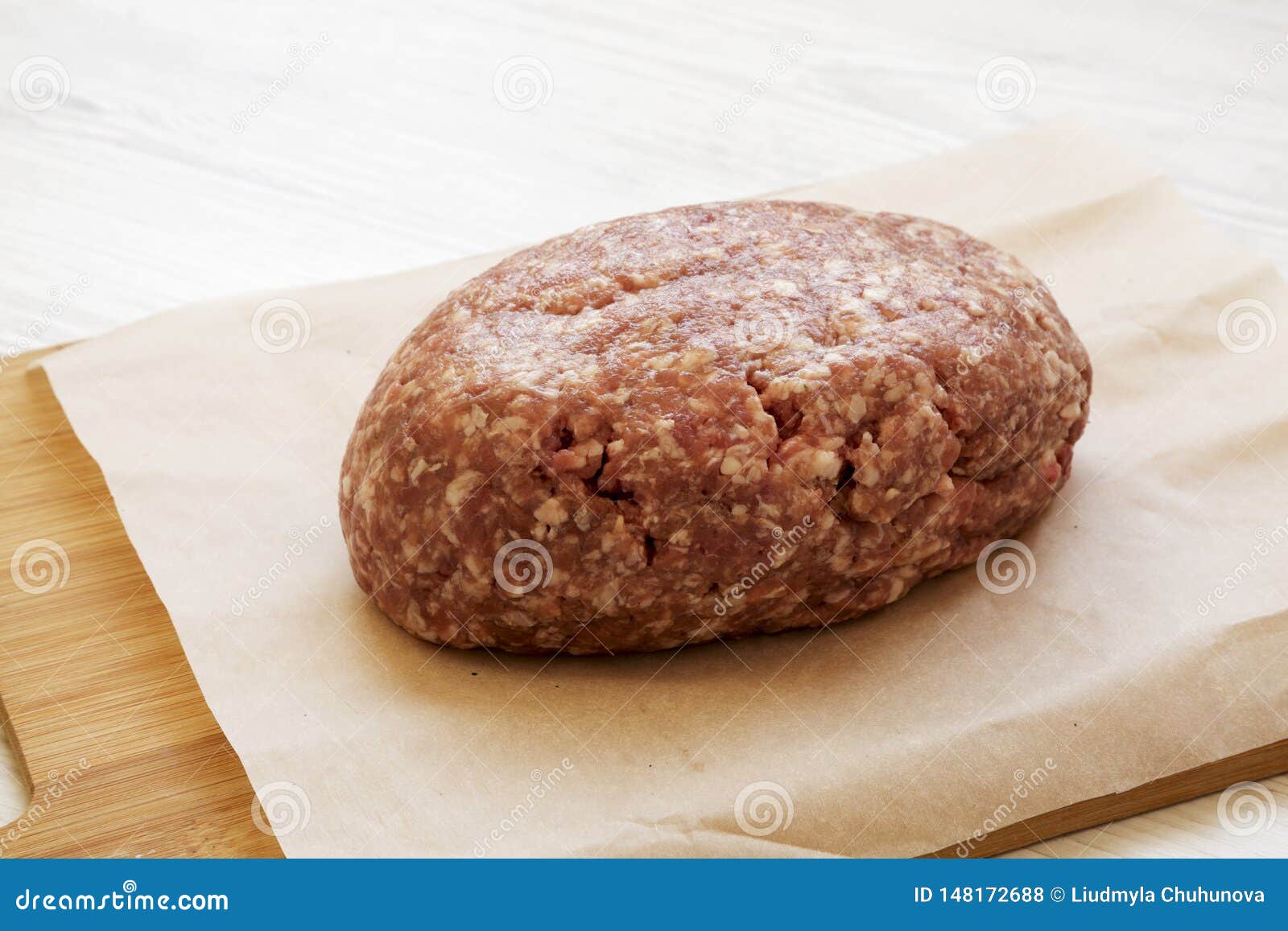 Fresh Raw Grass Fed Ground Beef on a Bamboo Board, Side View. Closeup