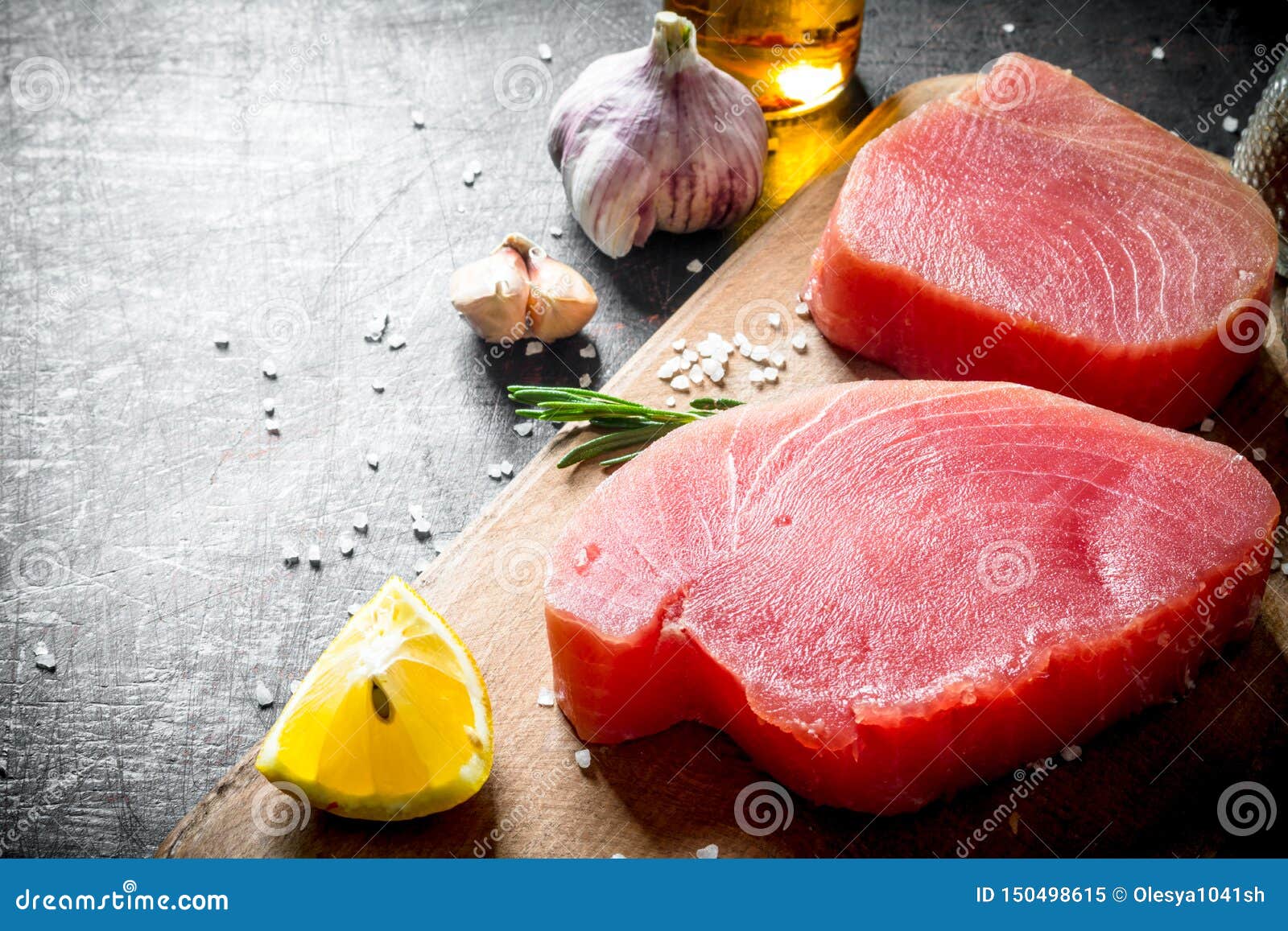 Fresh Raw Tuna on a Cutting Board with Lemon and Garlic Stock Image