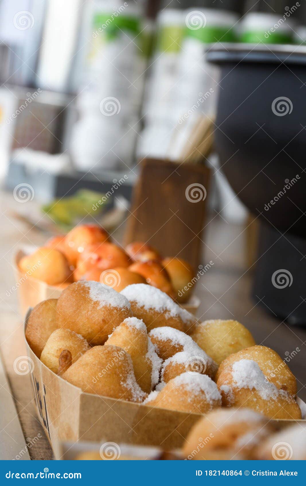 fresh round small donuts during carnival or fast food festival, glazed with dark and white chocolate