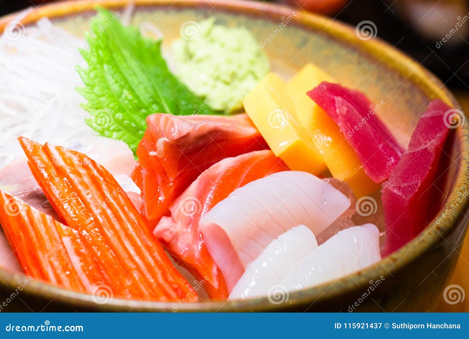 fresh salmon fish slice with tuna set.sushi set sashimi and sushi rolls served on black stone slate.close up.