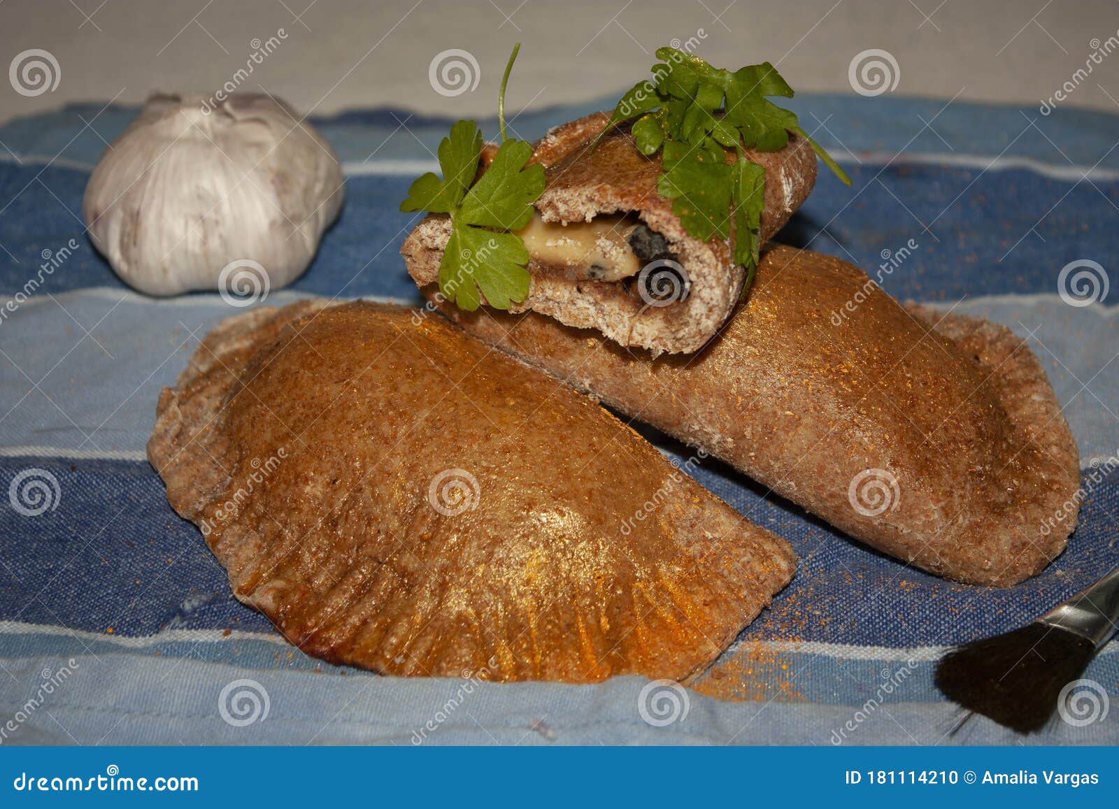fresh salted empanadas accompanied by the varnish brush and some ingredients such as garlic and parsley