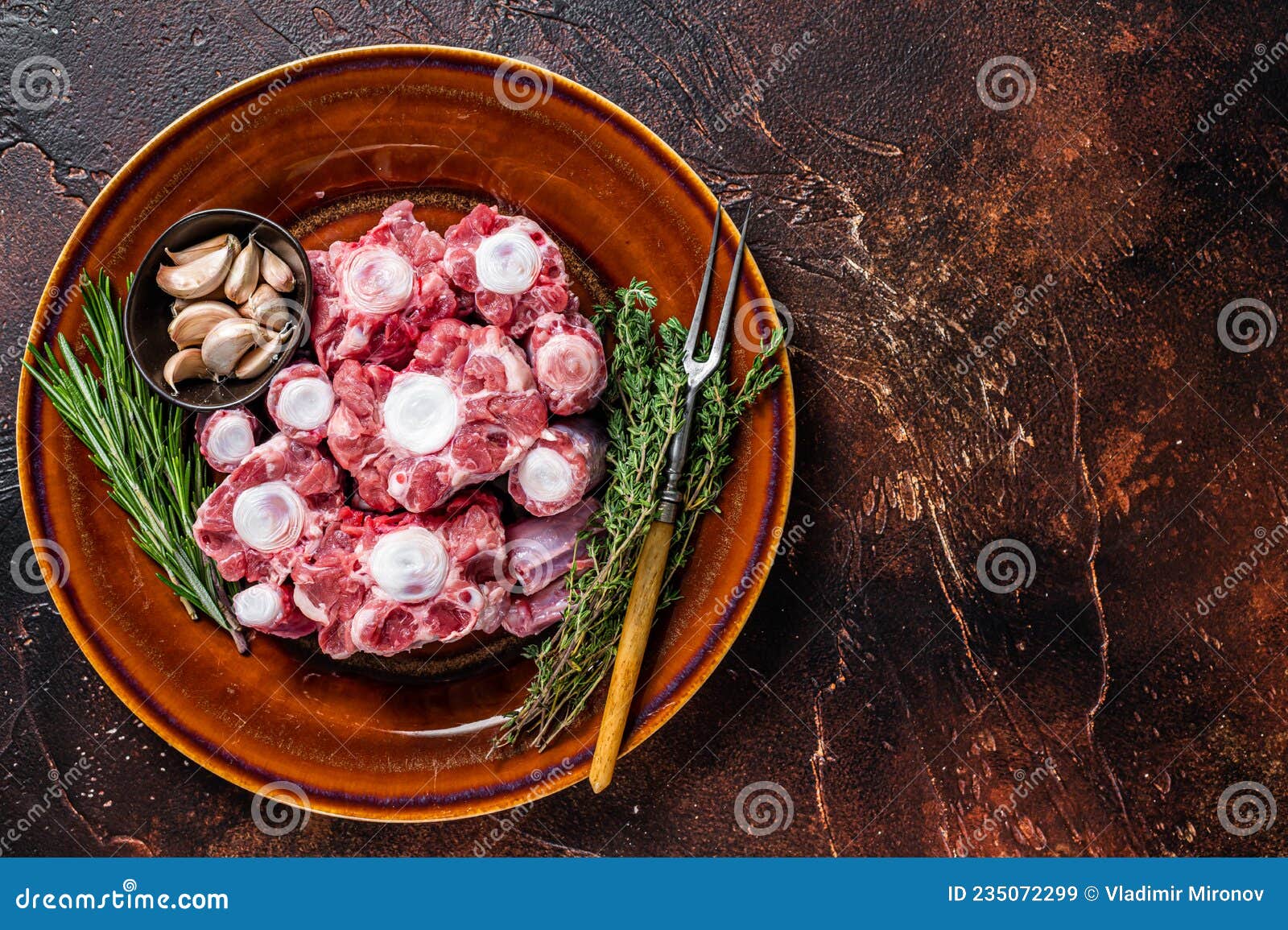 Fresh Uncooked Beef Oxtail Cut Meat on Rustic Plate with Herbs. Dark