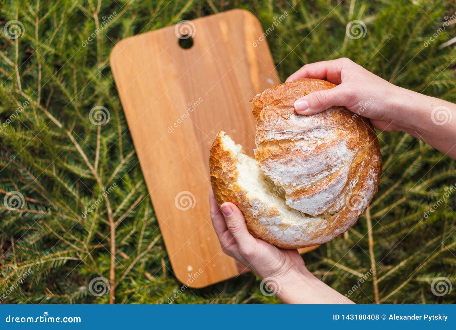 Fresh White Bread on a Cutting Board on the Background of Green