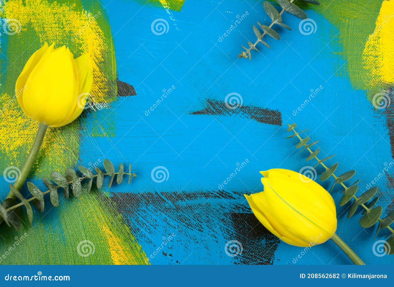 fresh yellow tulips with eucalyptus leaves flat lay on colourful abstract acrylic background. off-center composition.