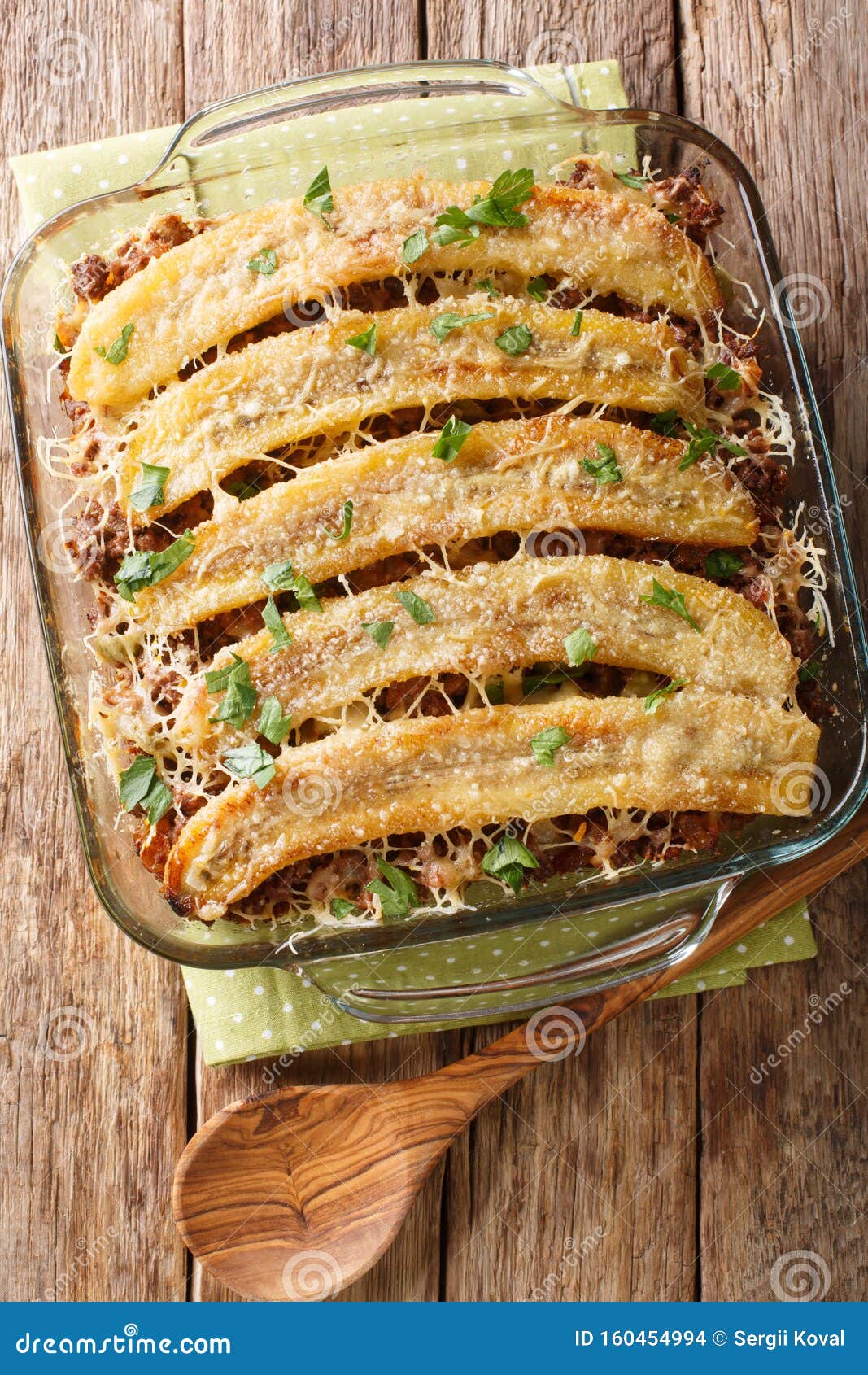 freshly baked pastelon de platano maduro casserole close-up in a baking dish. vertical top view