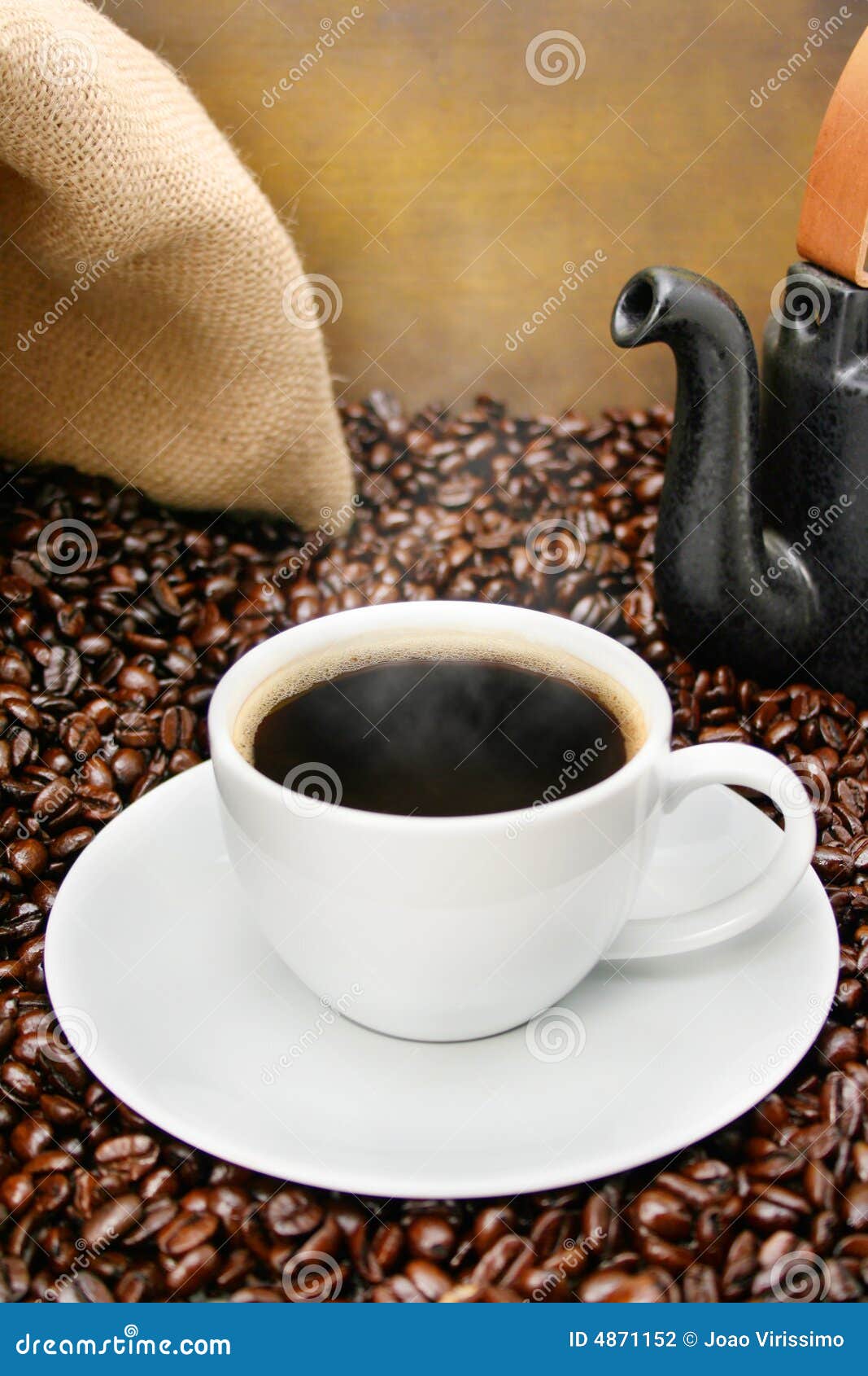 freshly brewed coffee cup over roasted beans