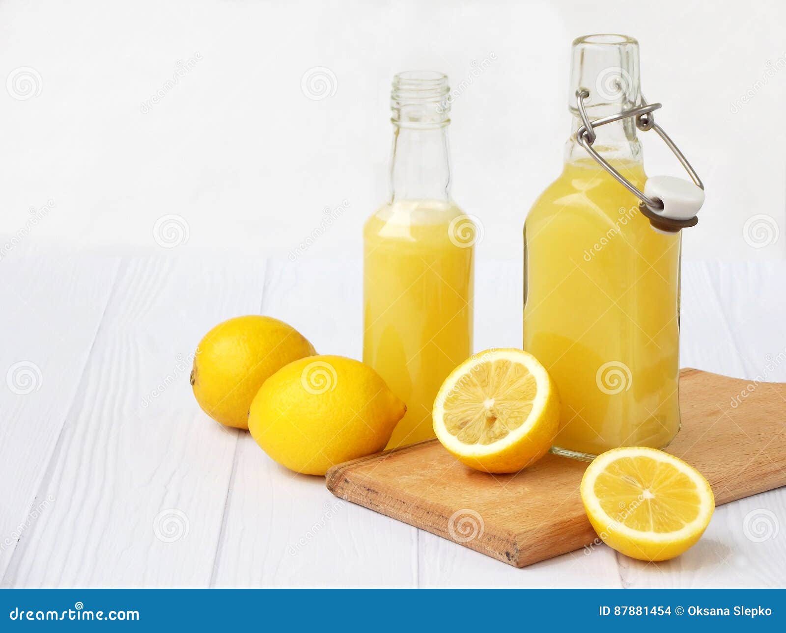 Freshly Squeezed Lemon Juice In Bottle And Lemons On Light Background. For Vitamin Drink Or