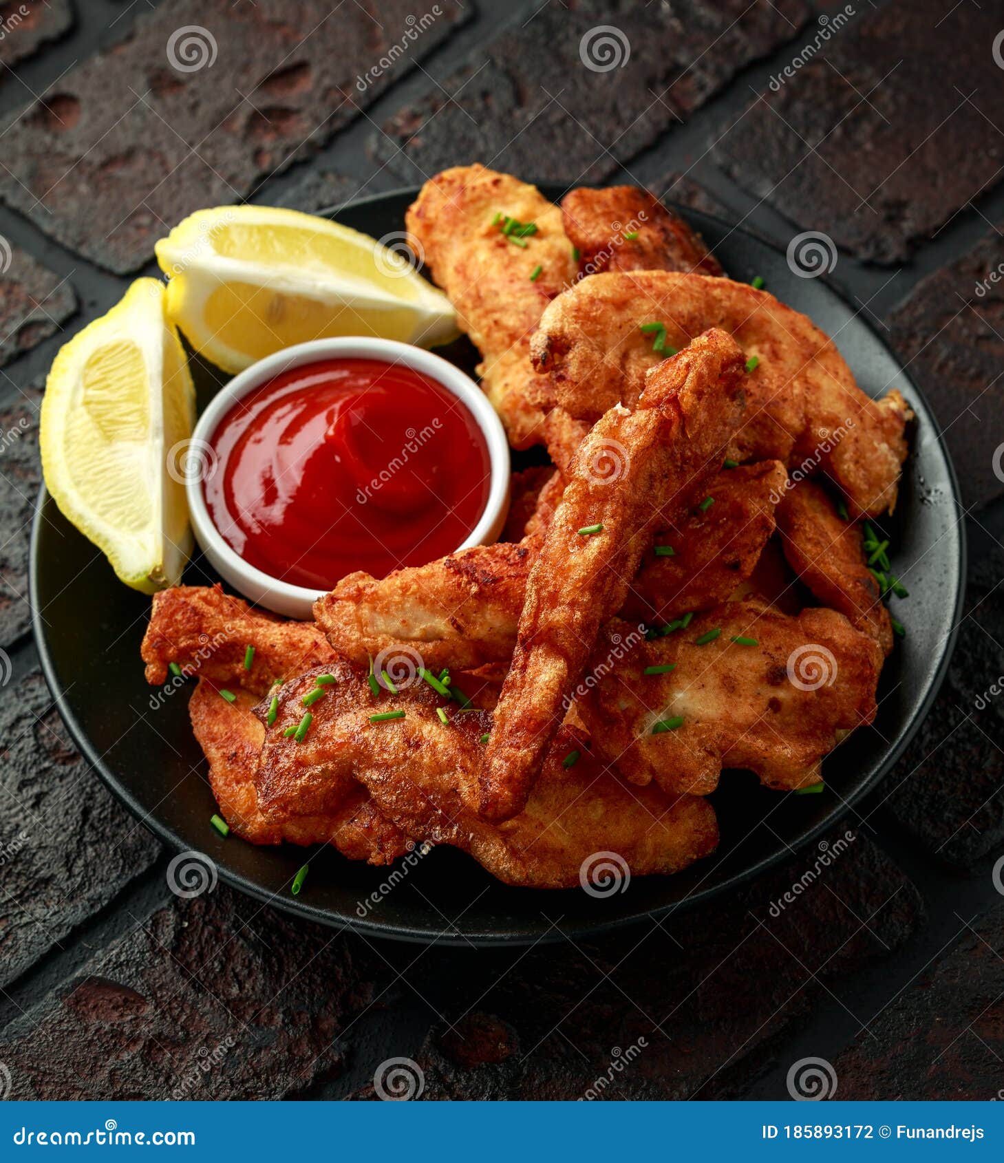 Fried Battered Chicken Breast Fillets Served with Lemon Wedges Stock