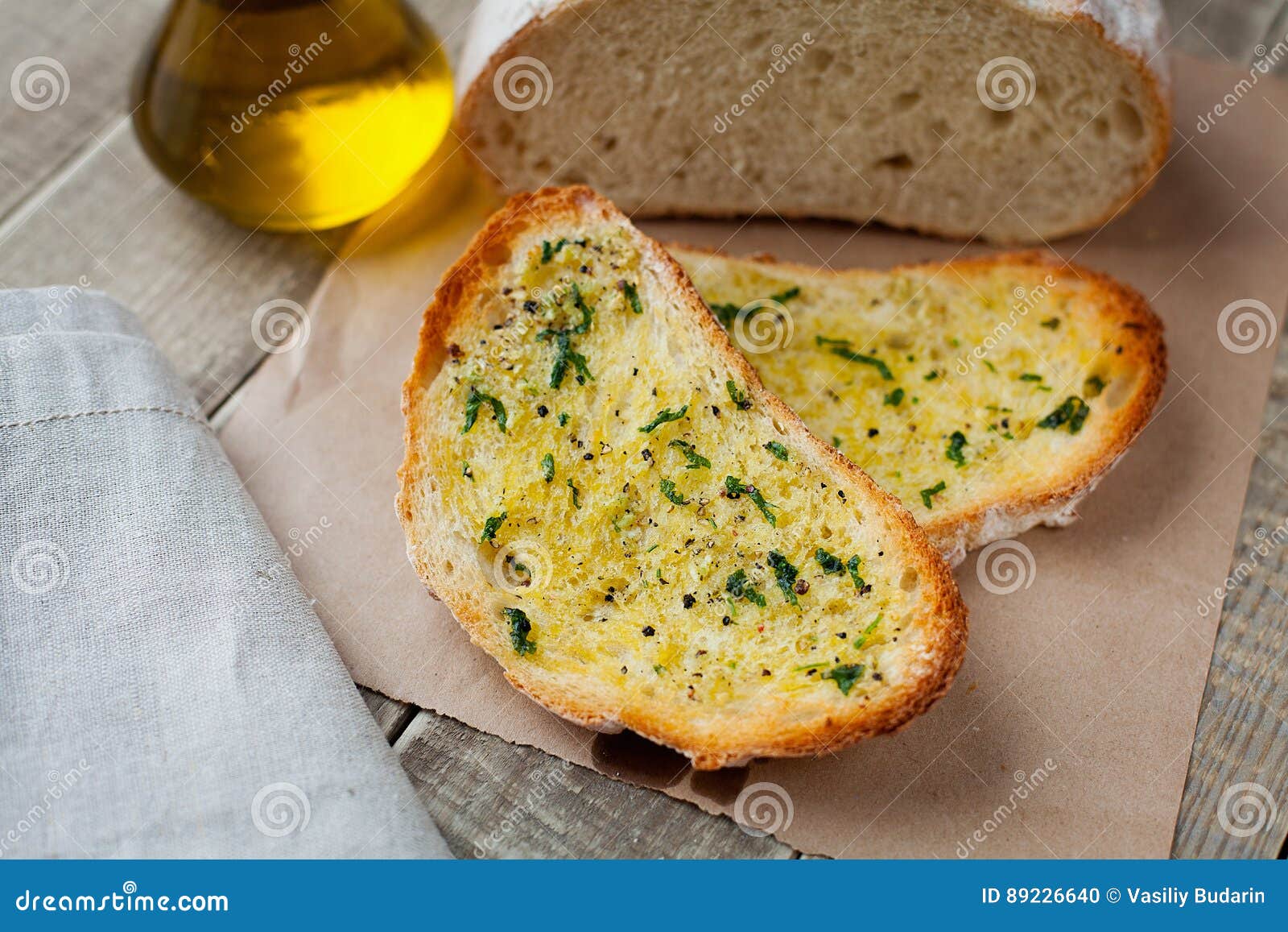 Fried Bread with Olive Oil, Garlic and Herbs on a Wooden Table. Rustic