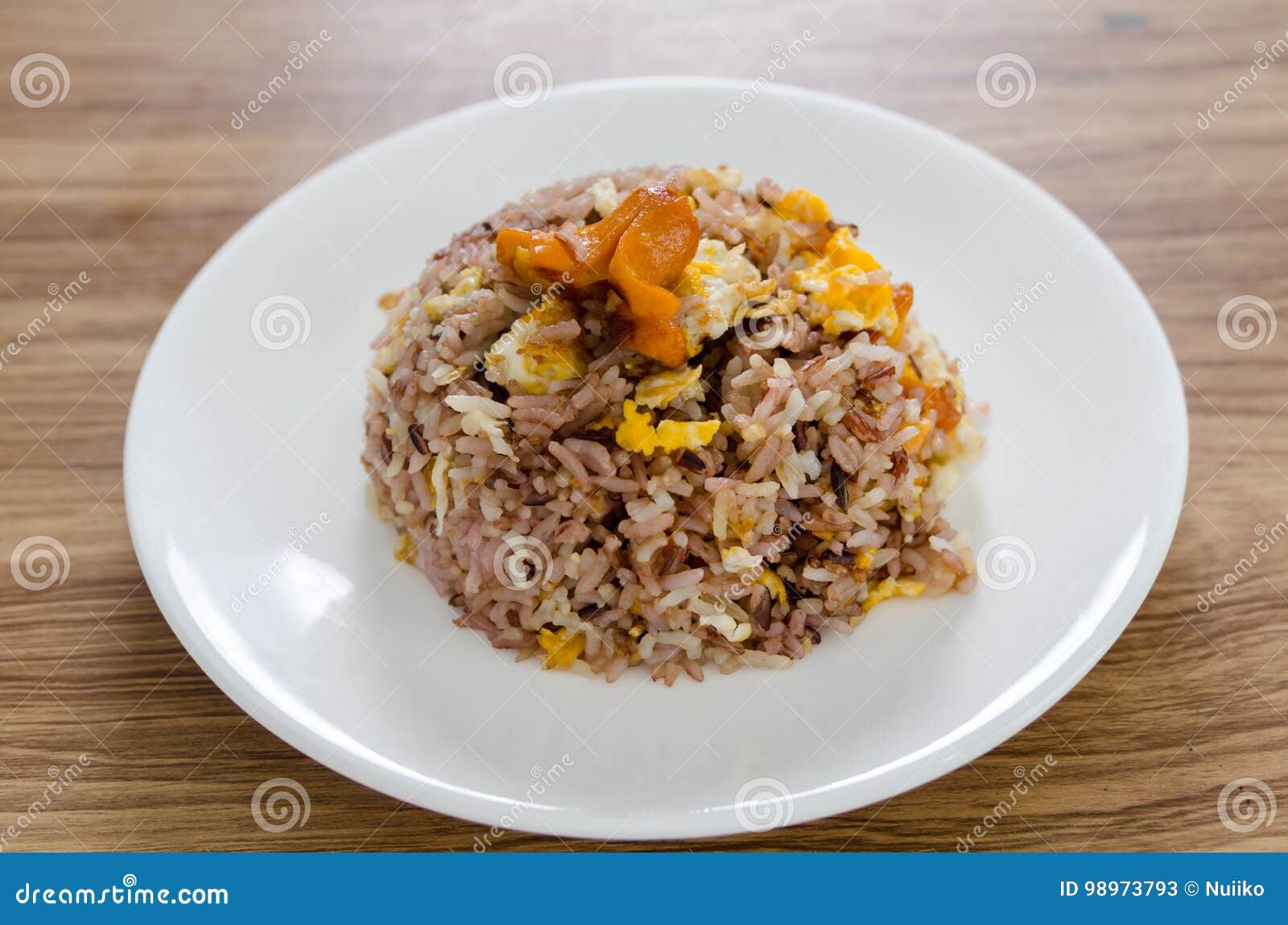 Fried Brown Rice with Eggs and Sausages on White Dish.. Stock Image