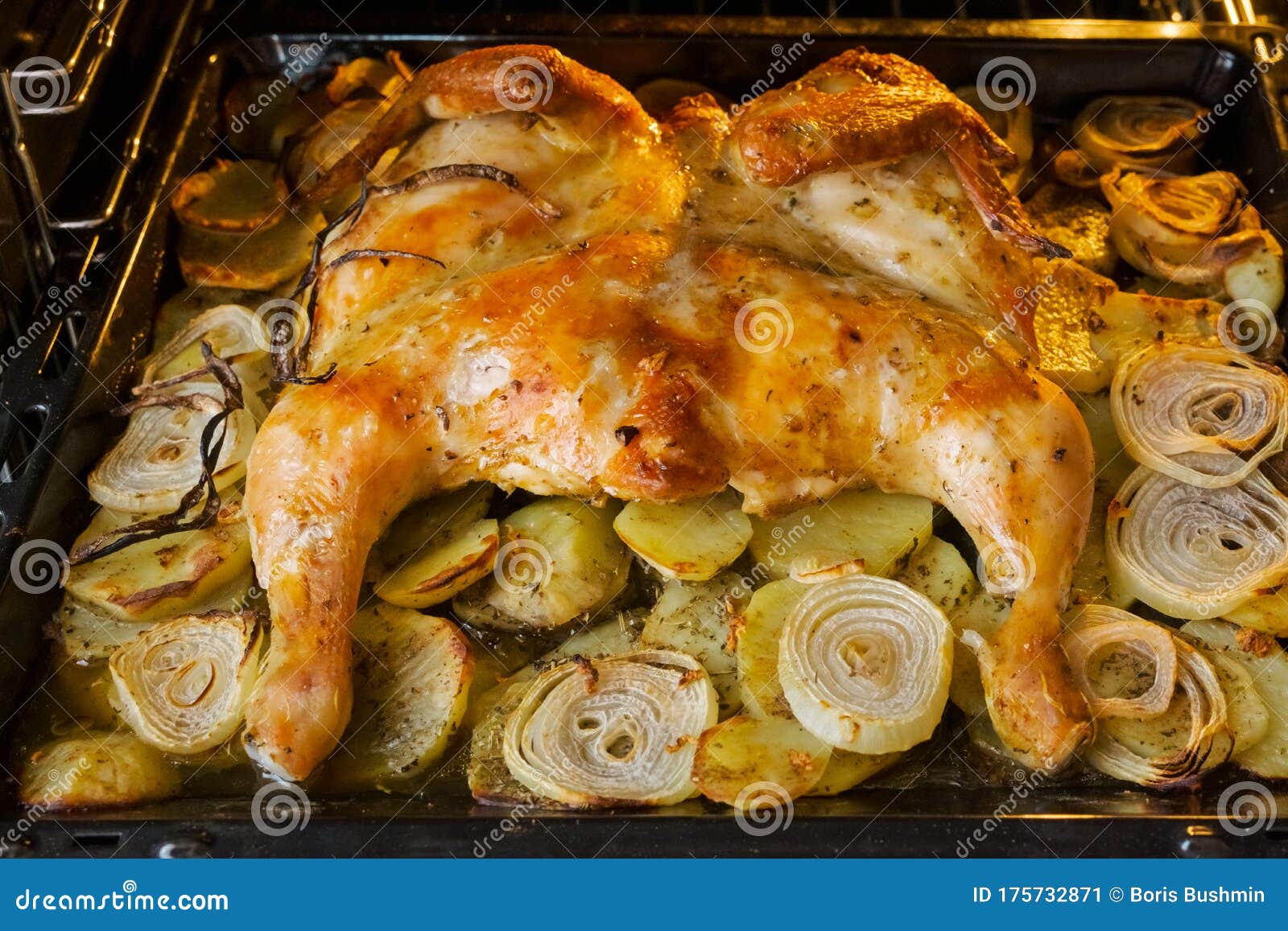 Fried Chicken with Baked Potatoes and Onions in the Oven Stock Image