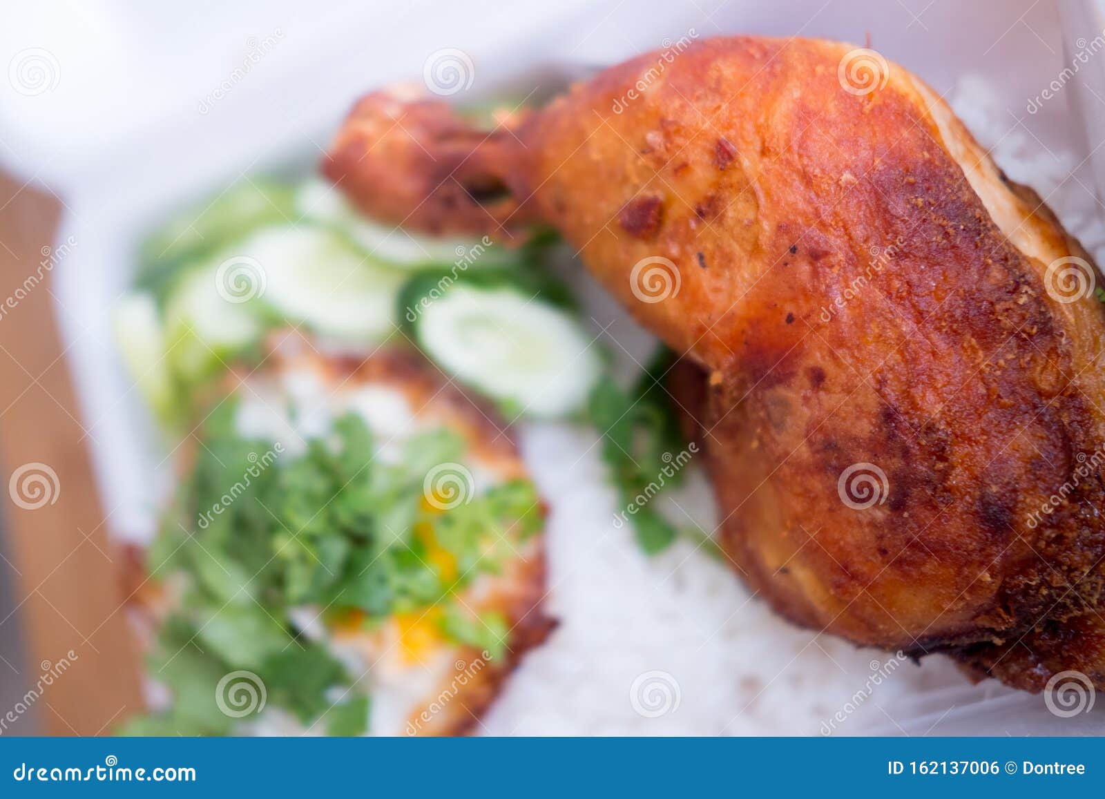 Fried Chicken Thigh with Fried Egg on Rice in from Box Stock Photo
