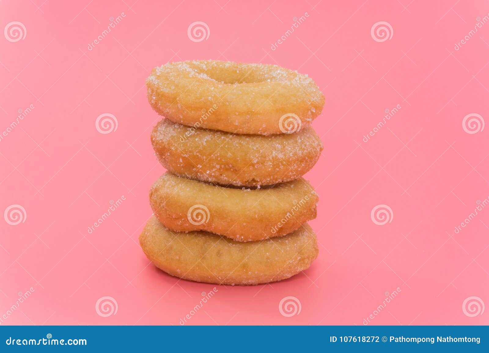 Fried Donuts com cobertura do açúcar no fundo cor-de-rosa