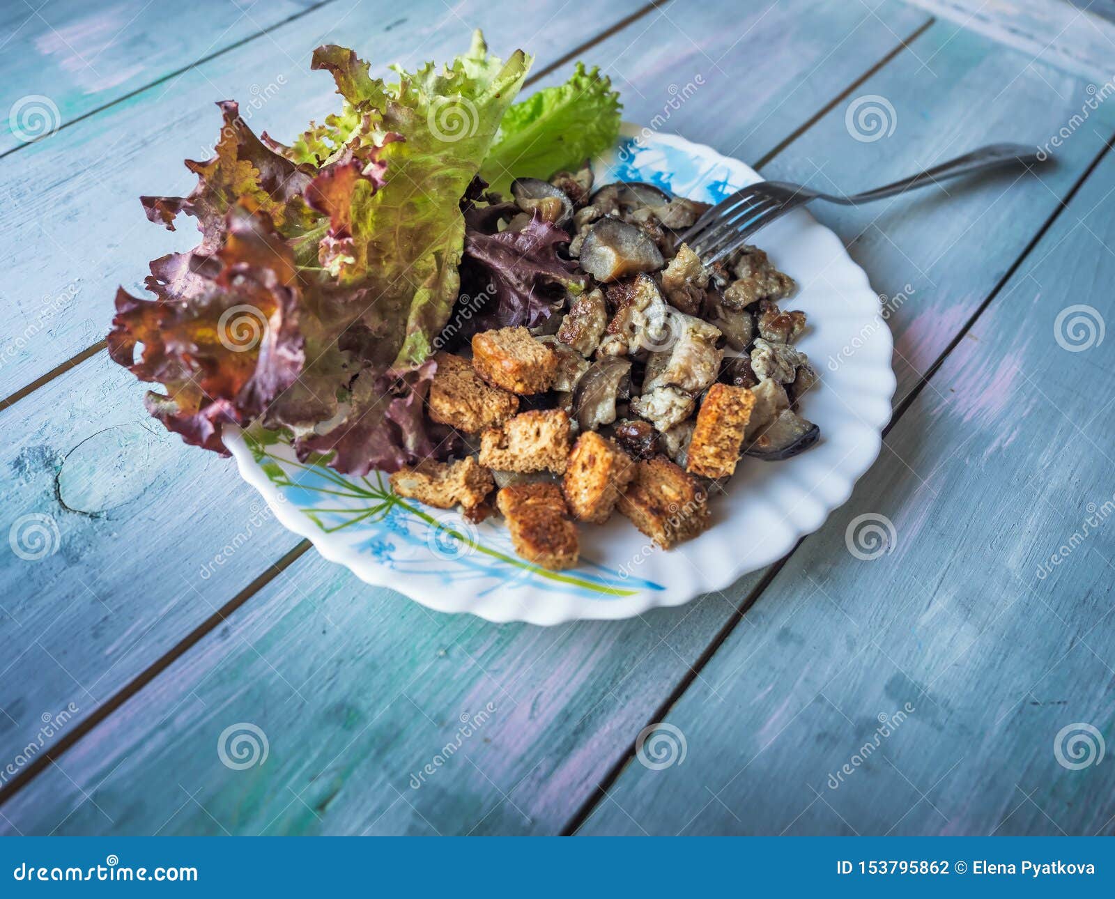 Fried Eggplant and a Leaf of Red Lettuce on a Round Plate Stock Photo