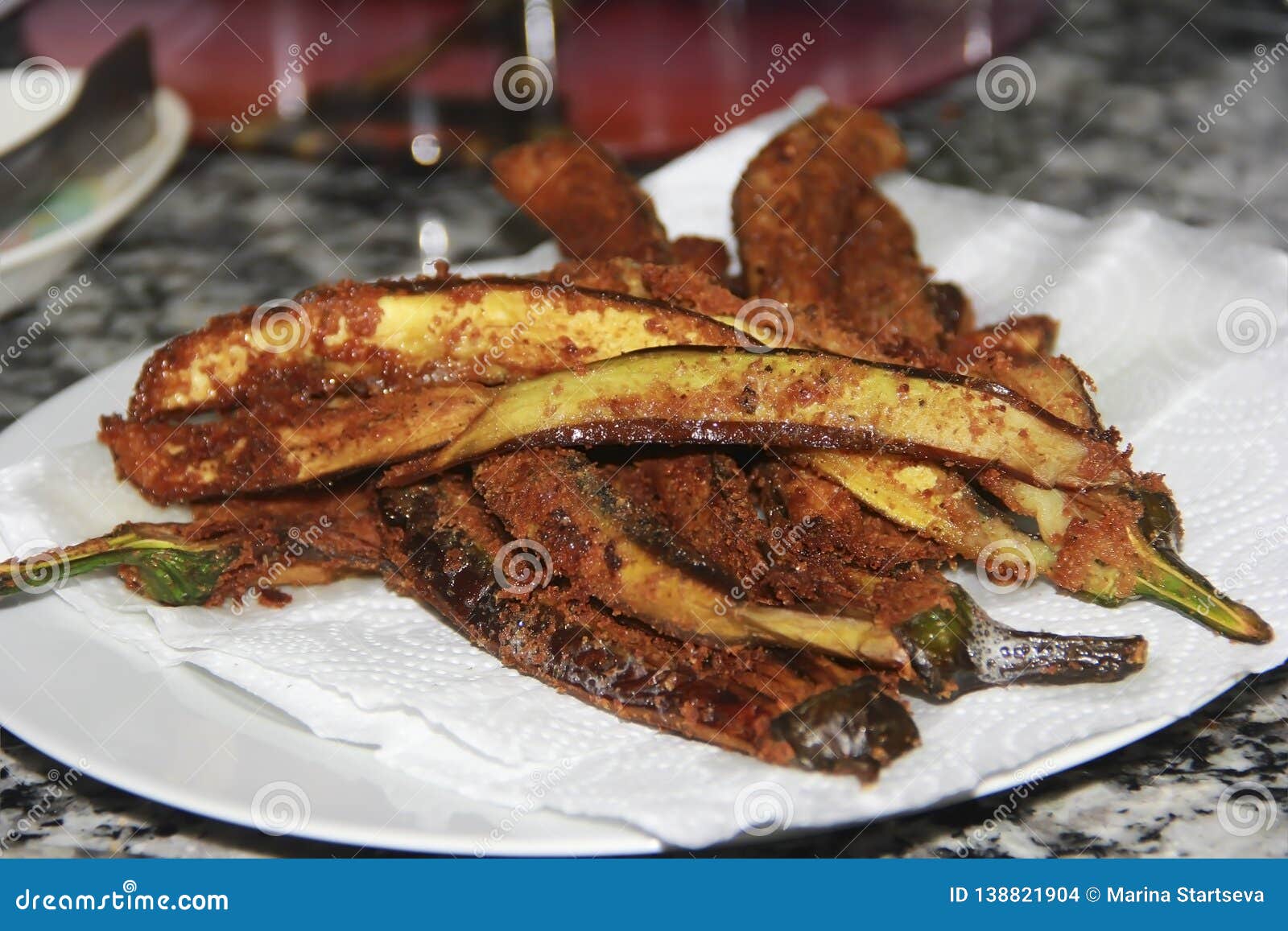 Fried Eggplants in Breading on a White Plate in the Kitchen Stock Photo