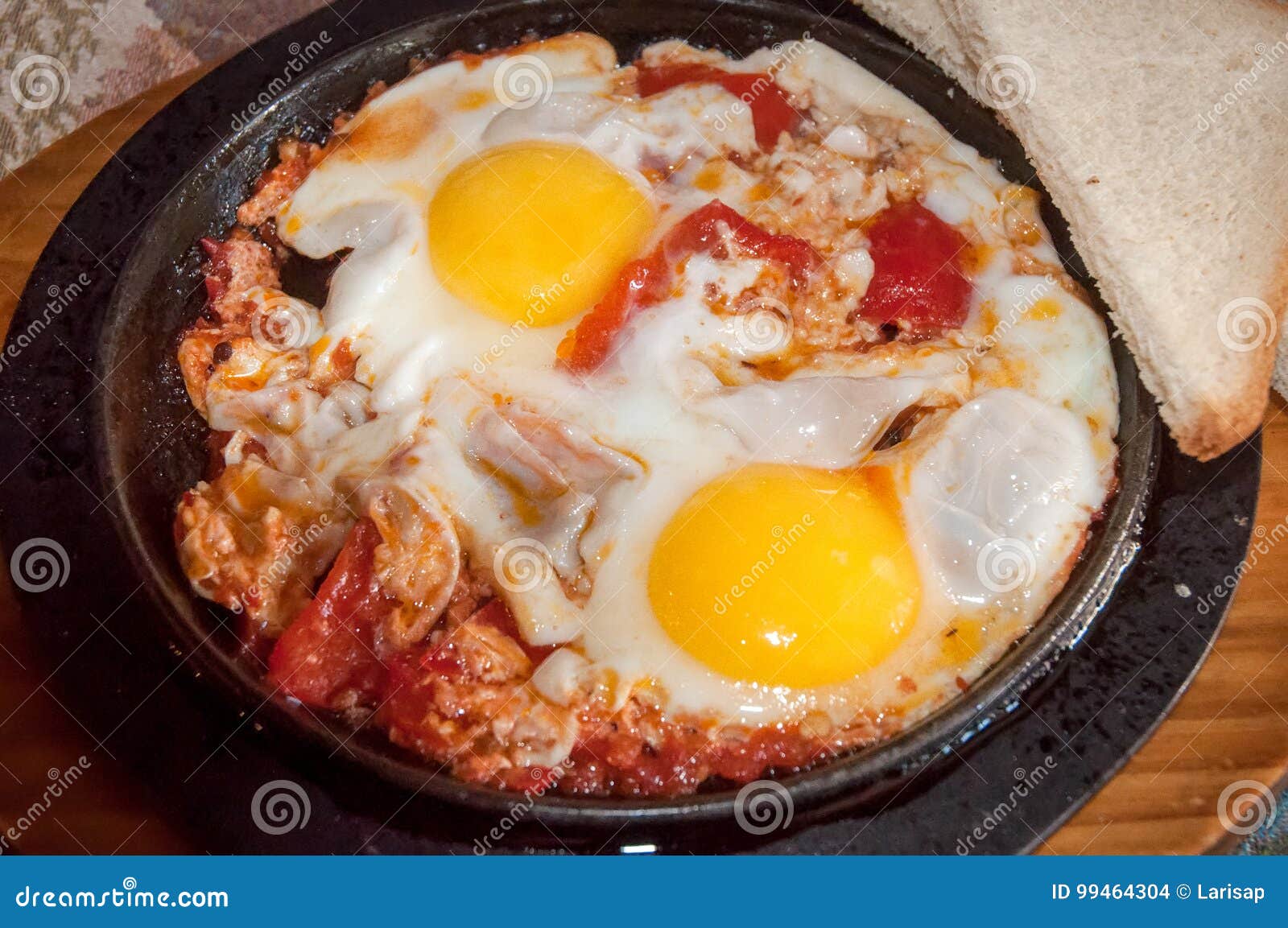 Fried eggs with tomatoes . stock photo. Image of background 99464304
