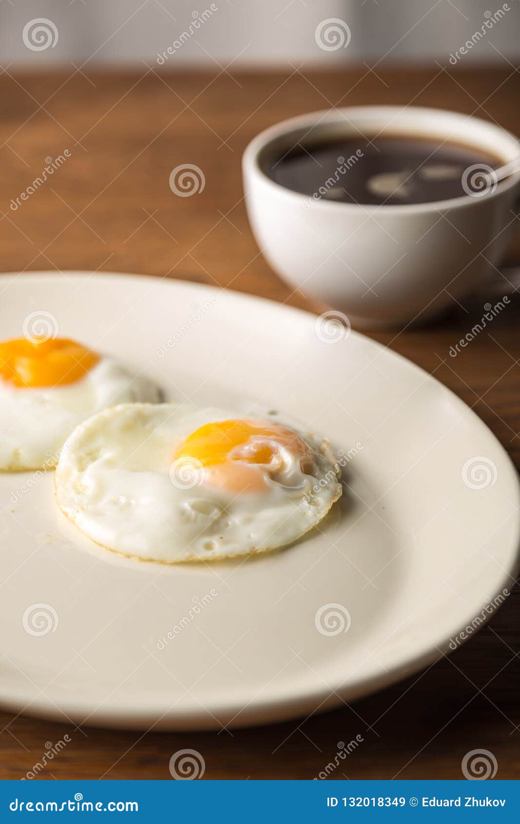 Fried Eggs On White Plate And Cup Of Black Coffee For Breakfast On