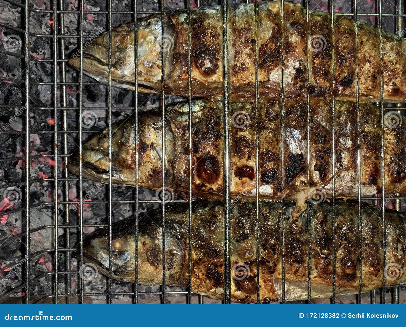 Fried Mackerel Cooked Over a Fire. Grilled Fish with Spices in a Grid