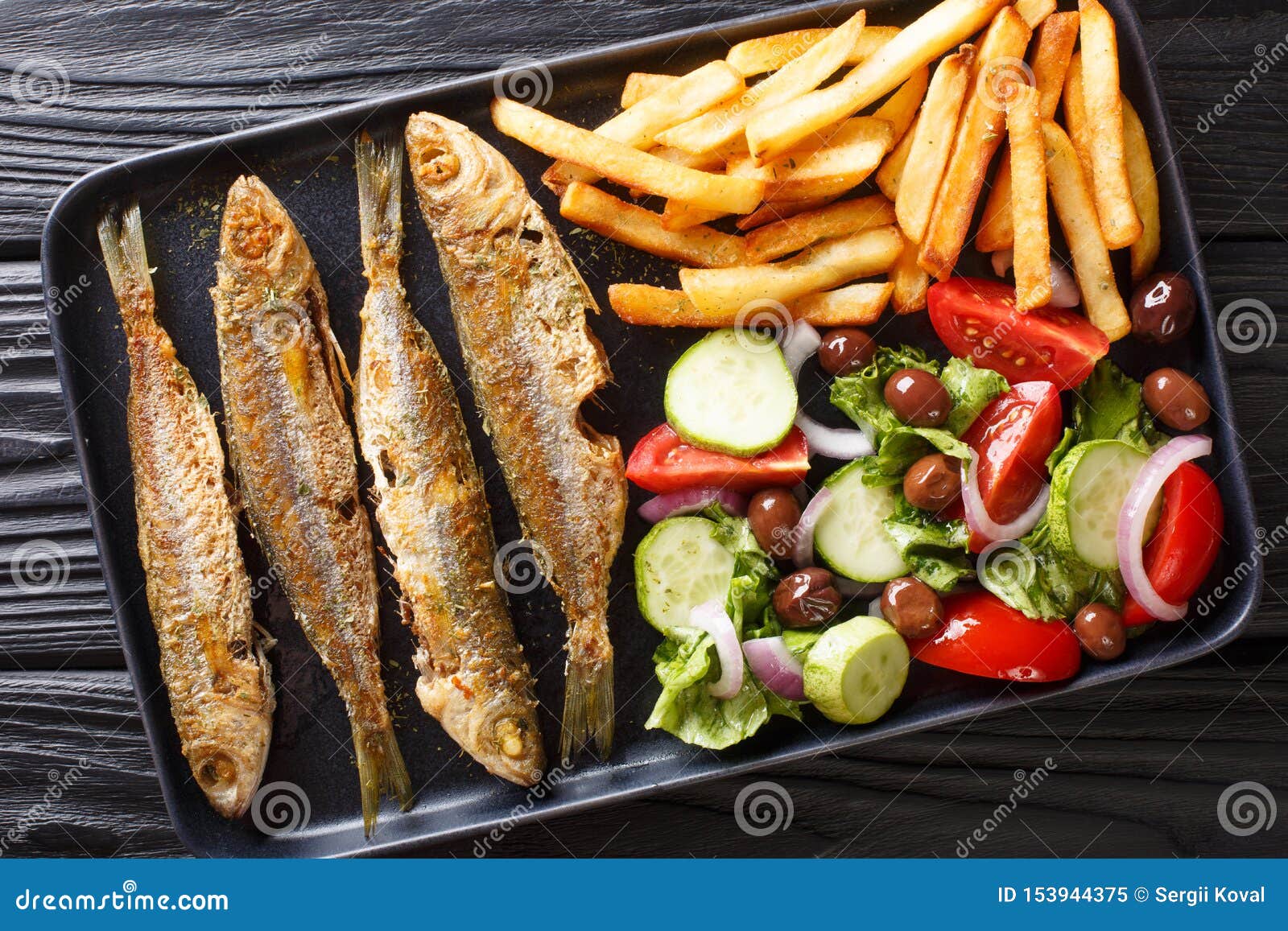 fried mediterranean boops boops fish served with fresh salad and french fries close-up on a plate. horizontal top view