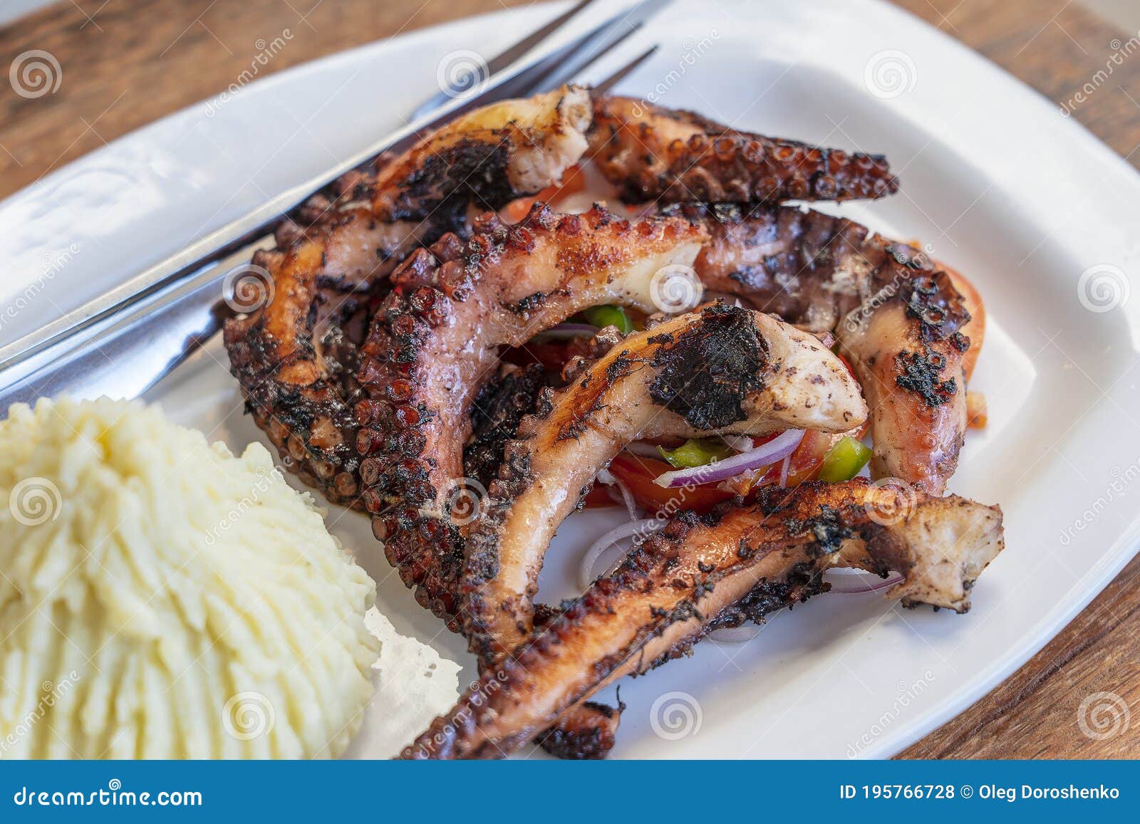 Fried Octopus Tentacles with Mashed Potato and Vegetable Salad on a