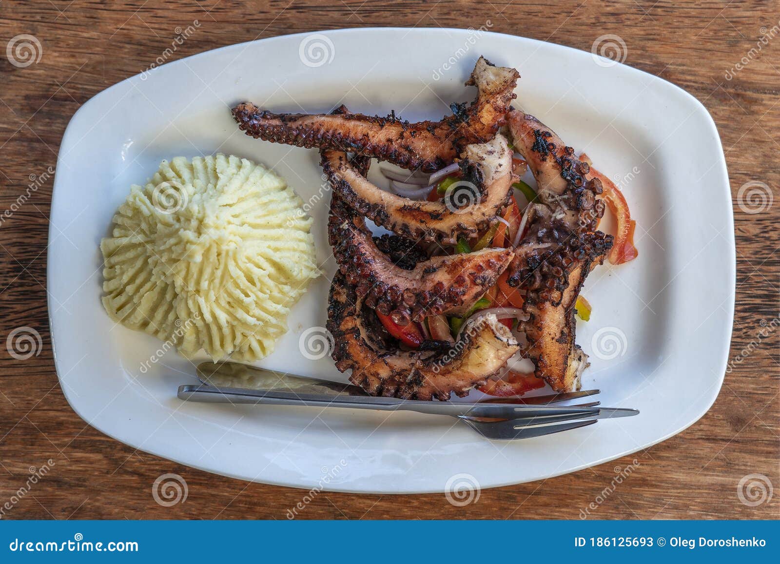 Fried Octopus Tentacles with Mashed Potato and Vegetable Salad on a