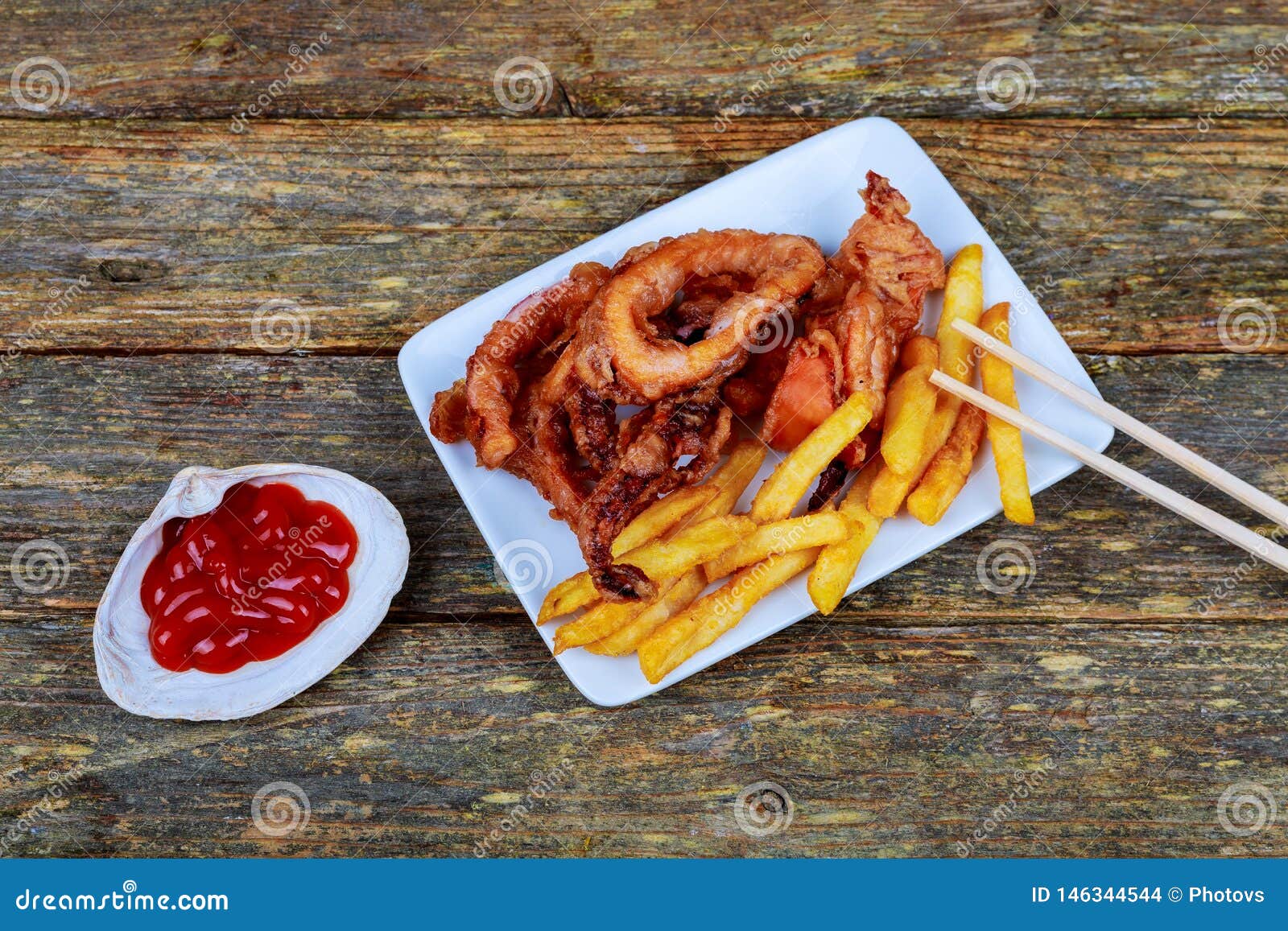Fried Octopus Tentacles with Potatoes Garnished with Sauce Stock Photo
