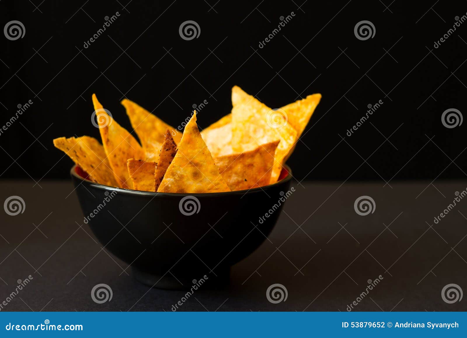 Fried spicy lavash chips in black tureen. Fried spicy golden lavash chips in black tureen