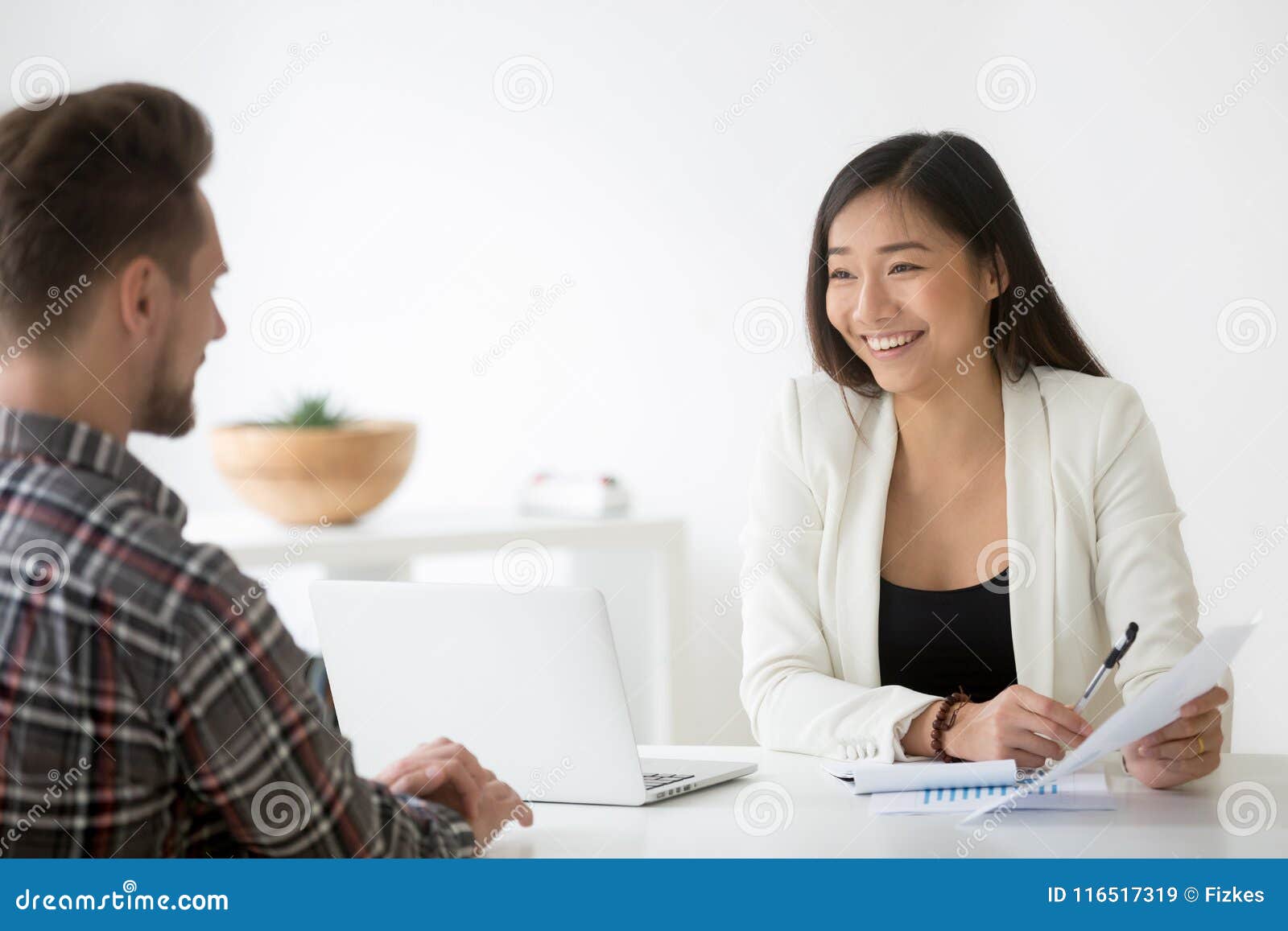 friendly asian hr smiling talking to candidate at job interview