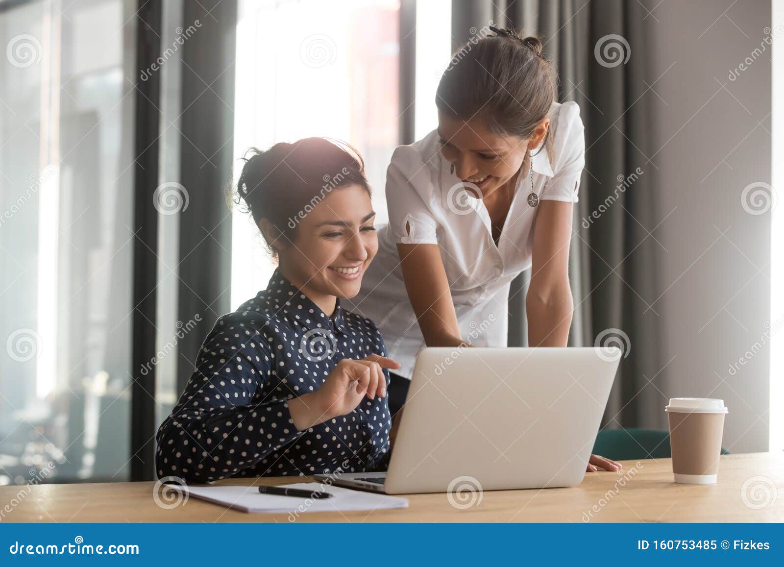 friendly caucasian mentor supervise indian intern secretary helping with computer