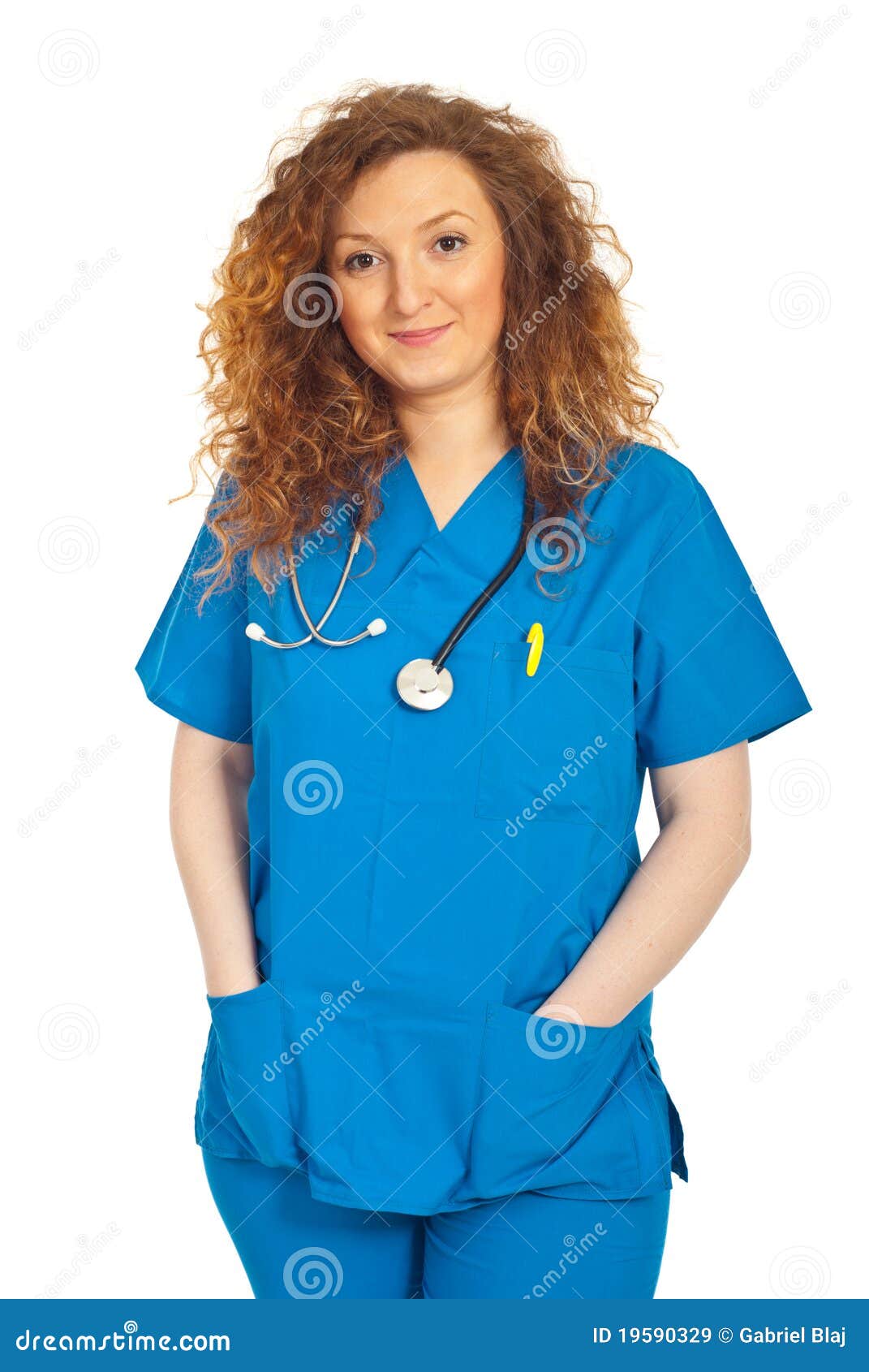 Friendly smiling doctor woman in blue uniform standing with hands in pockets isolated on white background