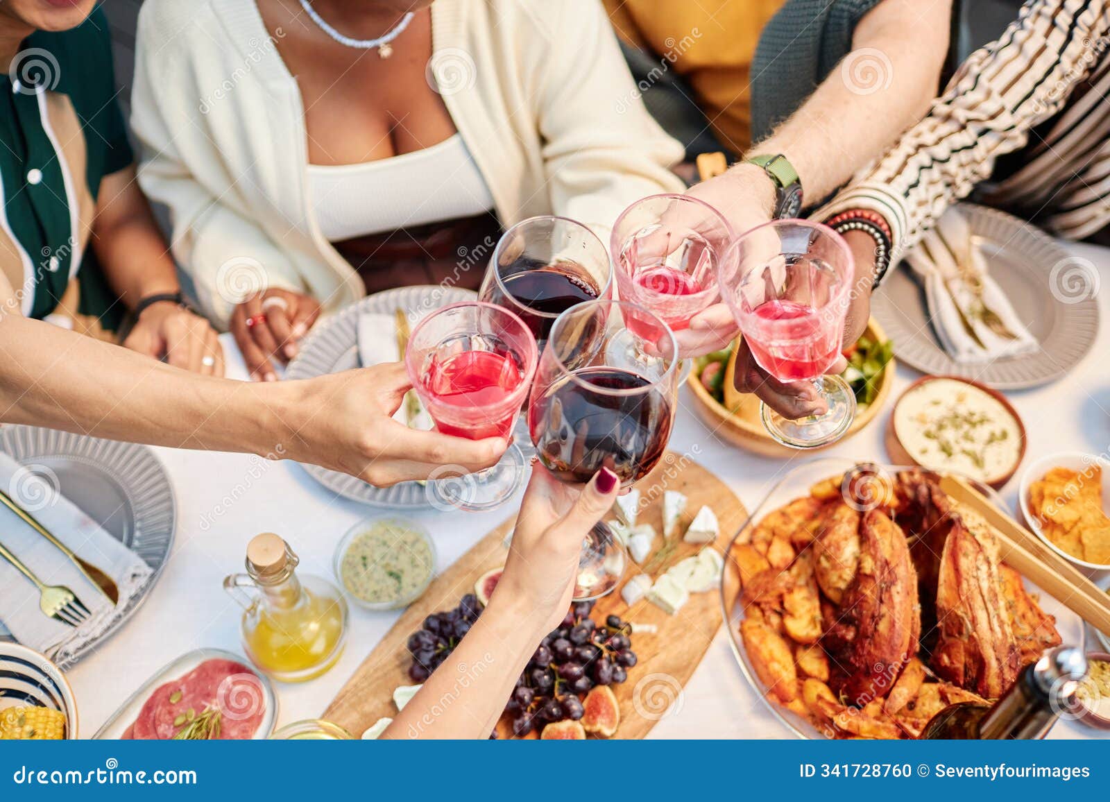 friends clinking wine glasses enjoying drinks