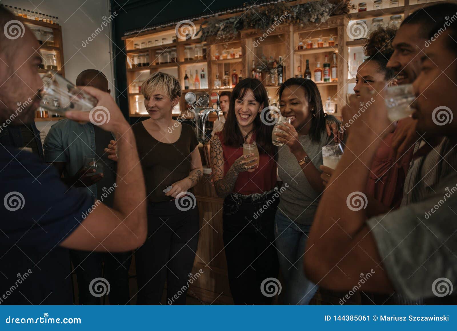 Friends Drinking And Talking Together In A Bar At Night Stock Image