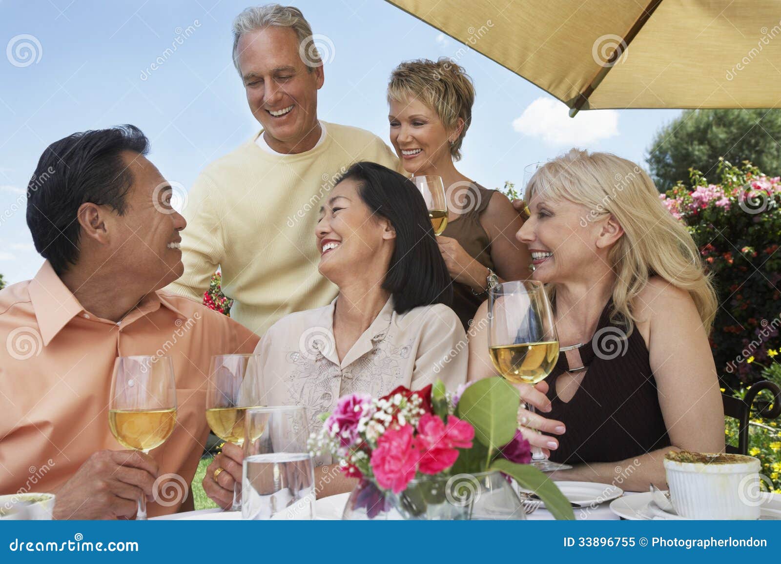 Friends Enjoying Drinks at Dinner Table Stock Image - Image of