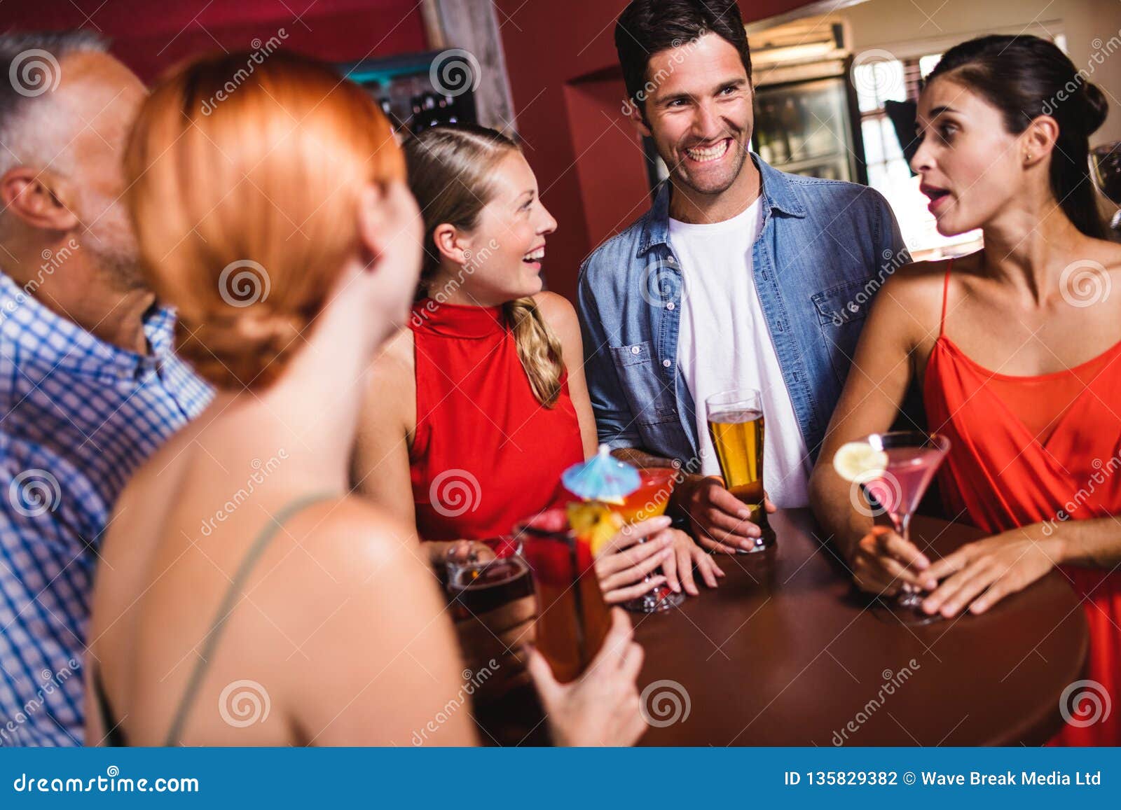 Friends Enjoying the Drinks at Table in Stock Photo Image