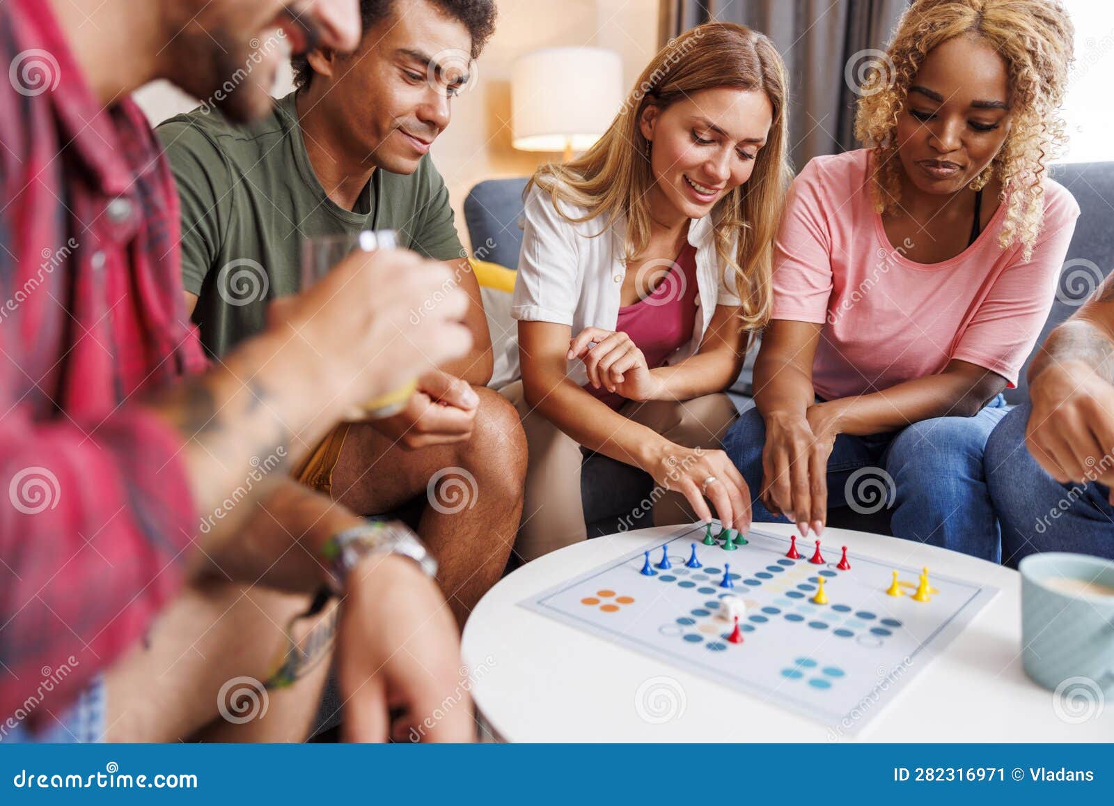 Friends Having Fun Playing Ludo Board Game while Spending Leisure