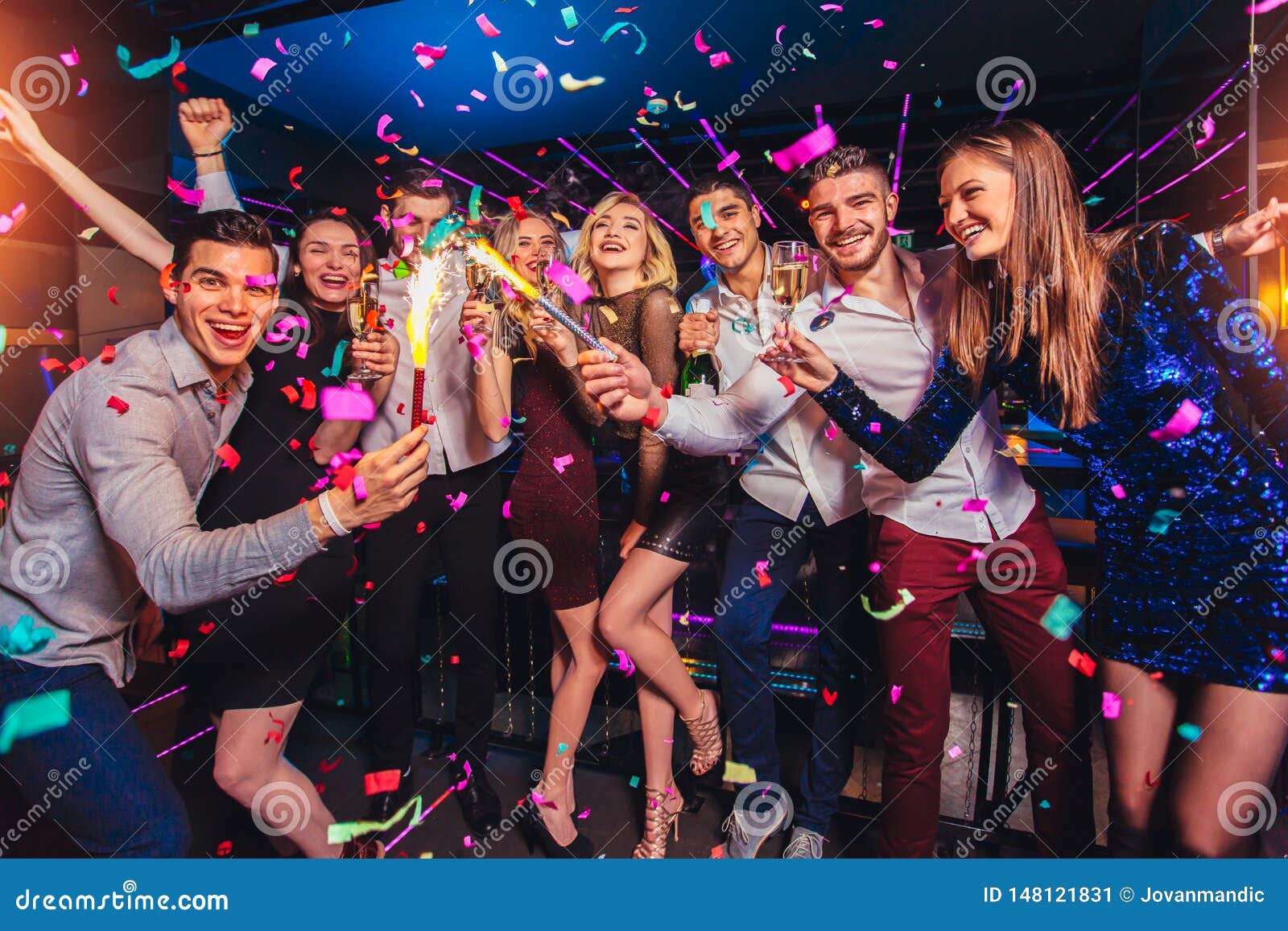 friends partying in a nightclub and toasting drinks