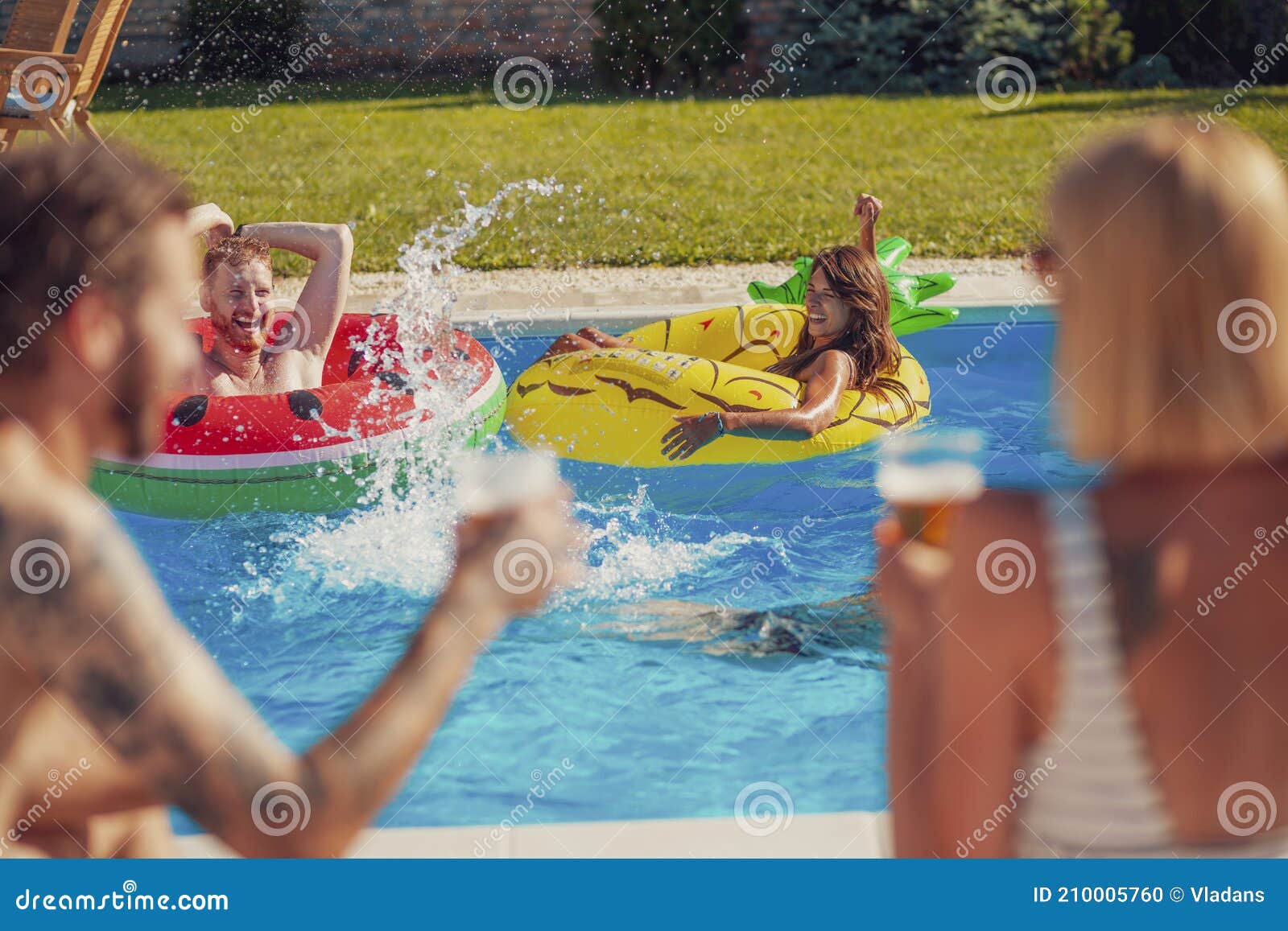 Friends Splashing Water And Drinking Beer At Swimming Pool Party Stock