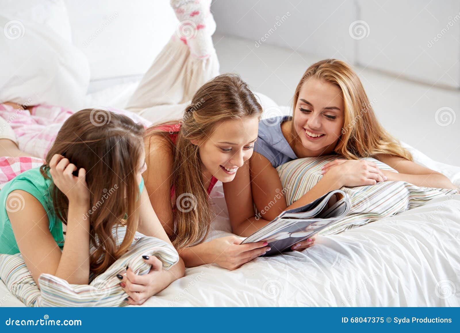 Friends Or Teen Girls Reading Magazine At Hom