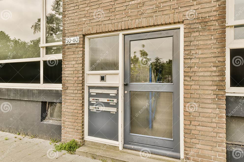 The front of a brick building with a black door stock photo image of