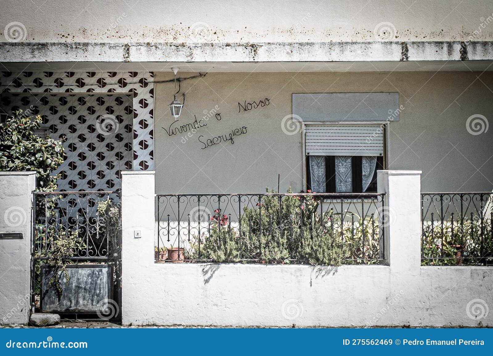 front facade of a residential house identified with the phrase, "vivenda o nosso sacrificio"
