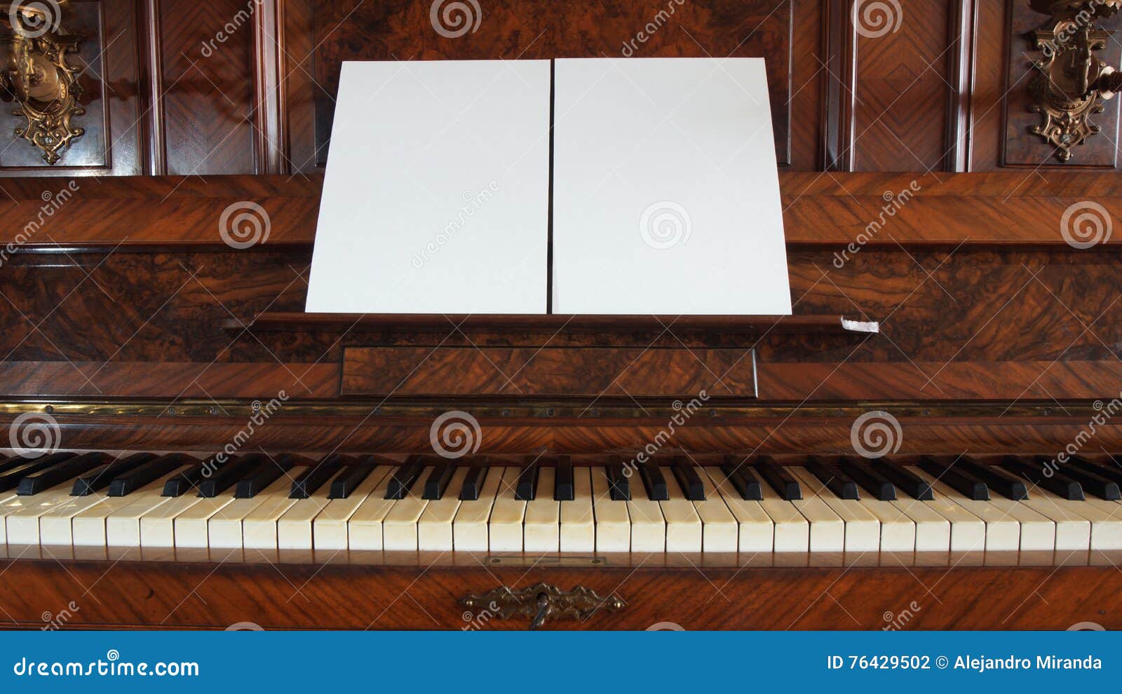 Front View of an Antique Piano with the Keyboard Open and Two Sheets of